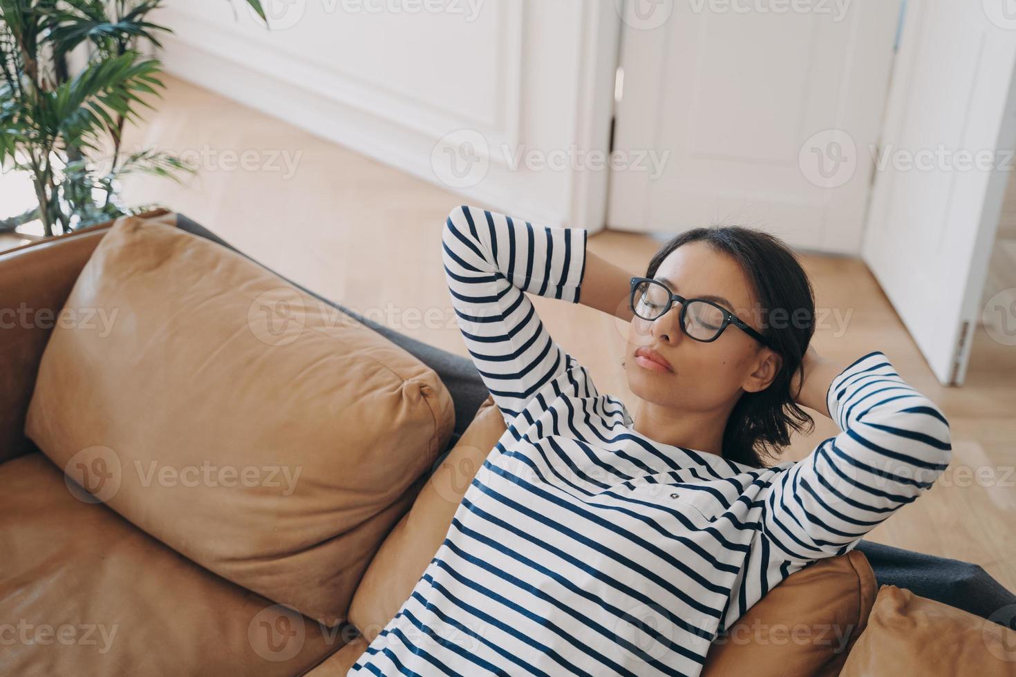 la mujer cansada descansa en el sofá, toma un descanso, disfruta de la