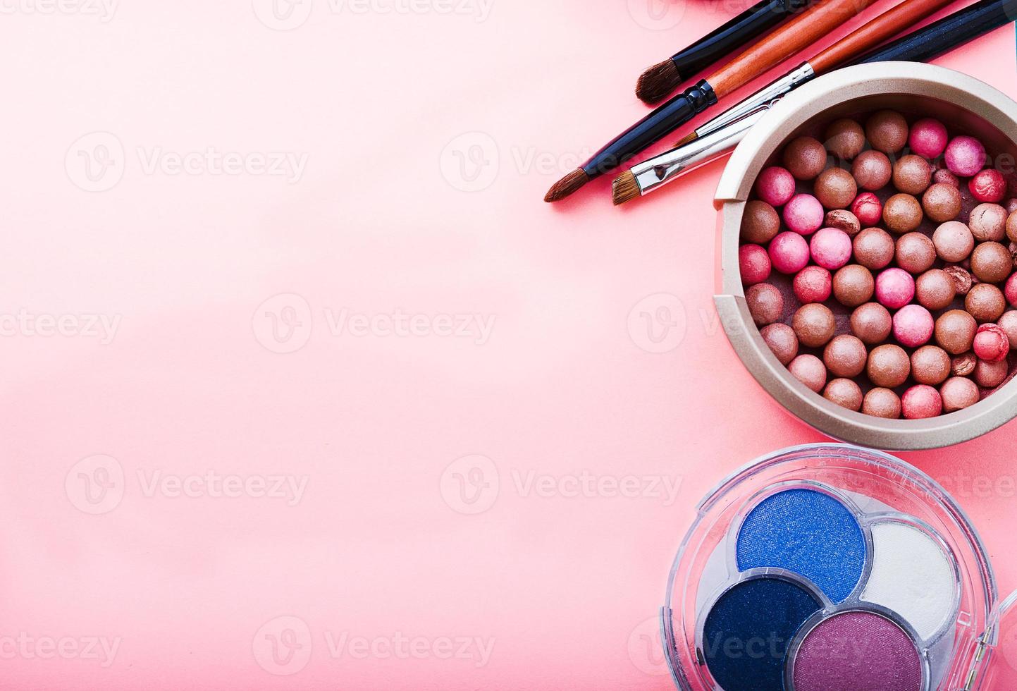 Frame of cosmetic accessories on pink background with copy space. Top view photo