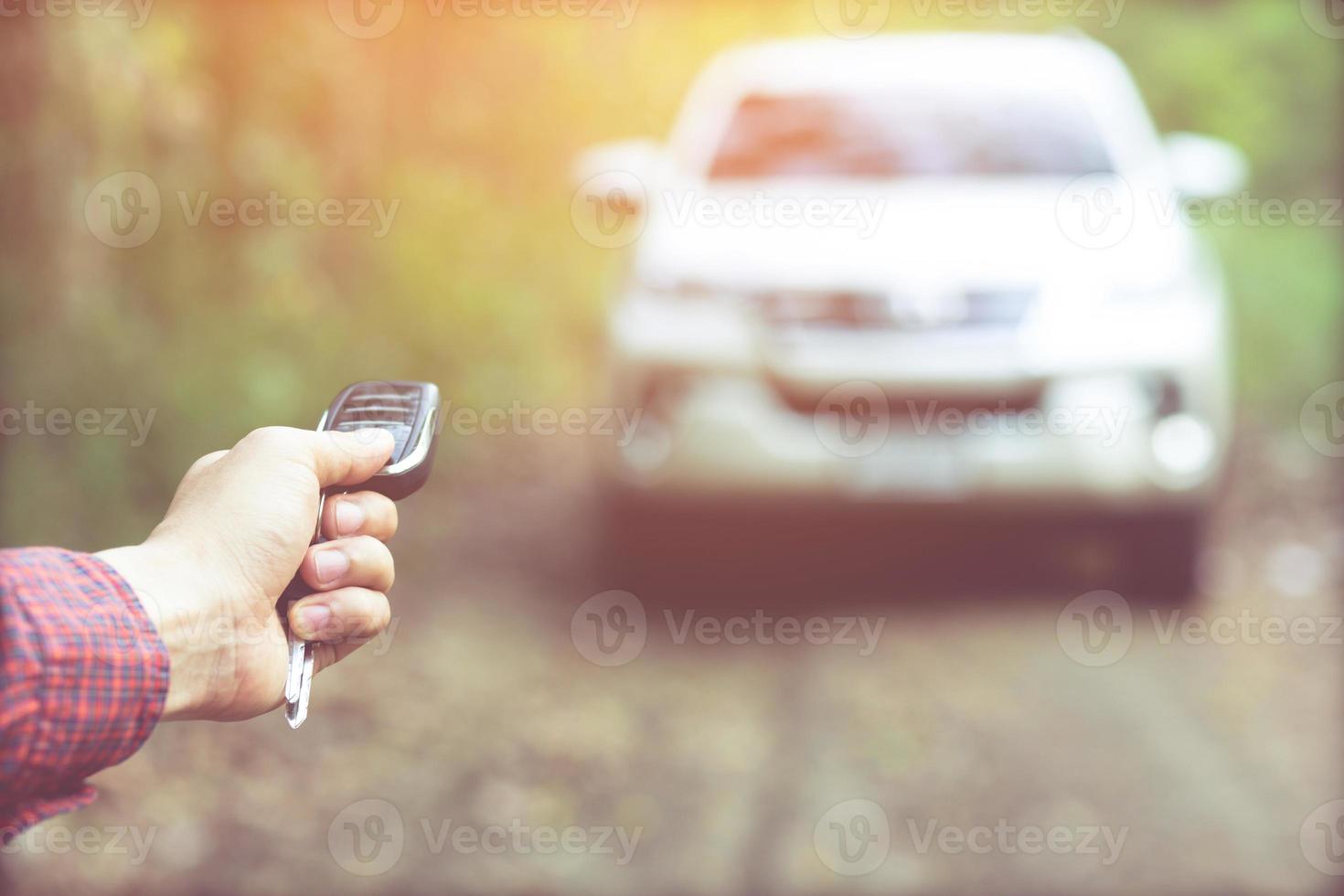 Car key in business man hand.  hand presses on the remote control alarm systems. lock or unlock the door. photo