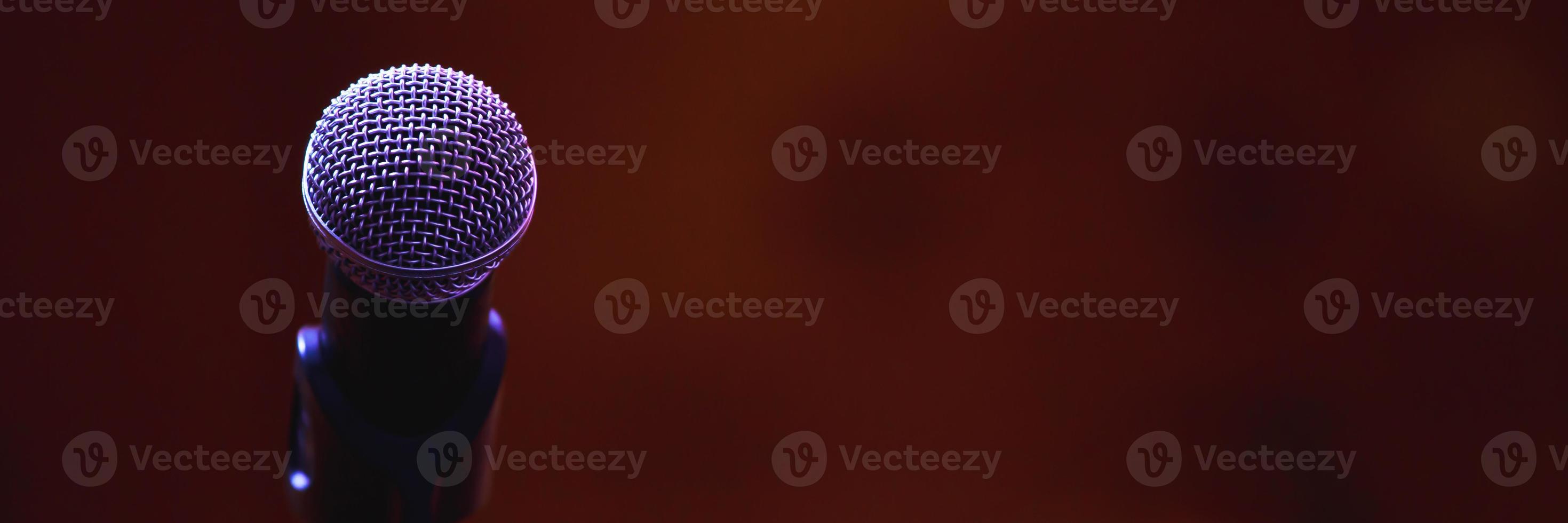 Close up of microphone on stage lighting at concert hall or conference room. copy space banner. soft focus. photo
