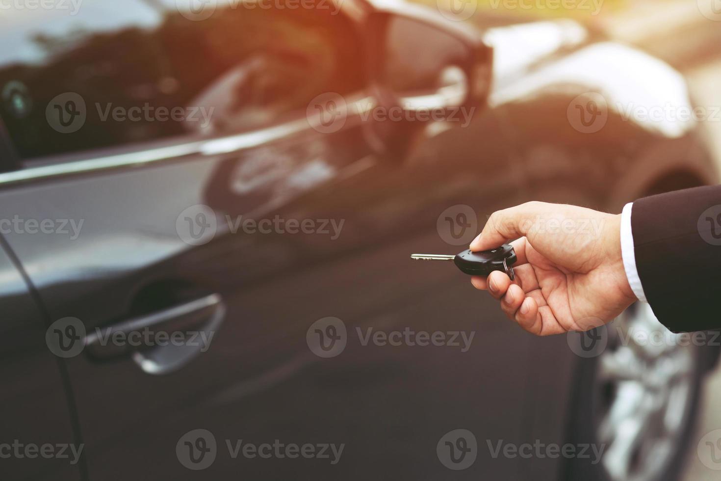 Car key in business man hand. hand presses on the remote control car alarm systems. lock or unlock the door. Leave space for writing text. photo