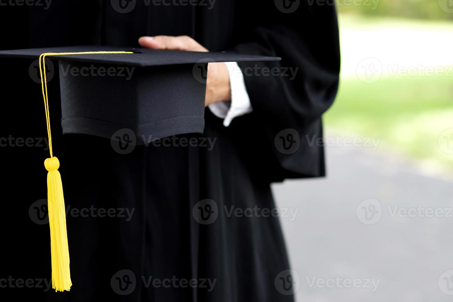 graduación, primer plano estudiante sosteniendo sombrero borla rojo con certificado de diploma en la mano durante el éxito de comienzo graduados de la universidad, grado de ceremonia de felicitación de educación conceptual. foto