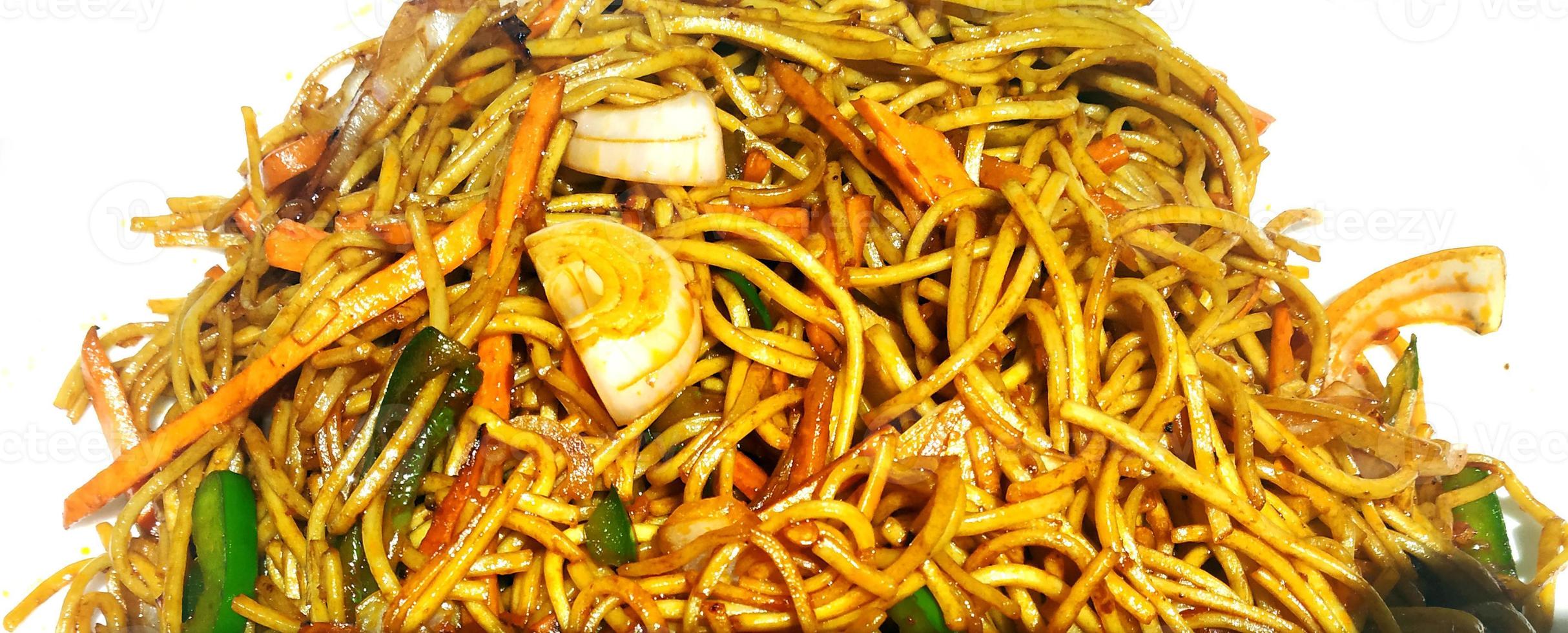 los fideos schezwan o los fideos vegetales hakka o chow mein son recetas populares de indochina, que se sirven en un tazón o plato foto