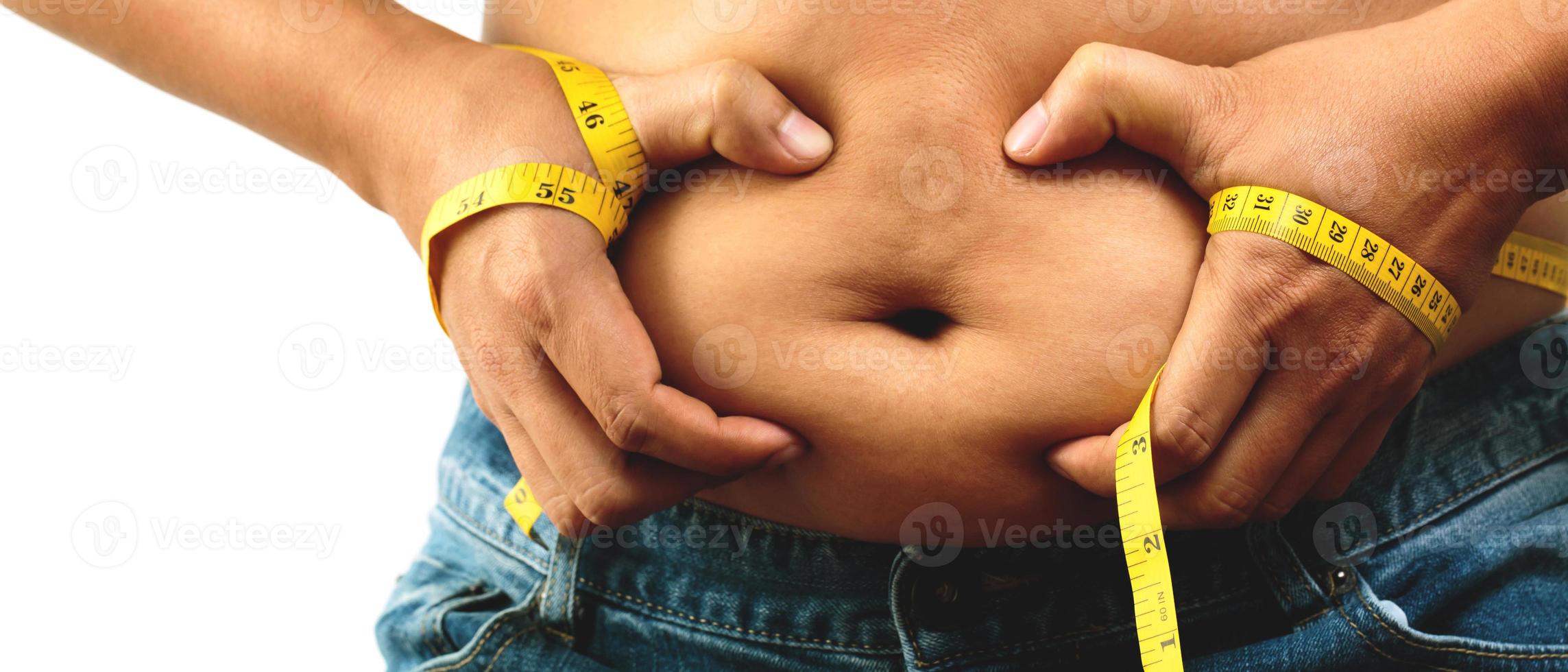 fat man check out body overweight abdomen his belly with in hand measuring tape photo