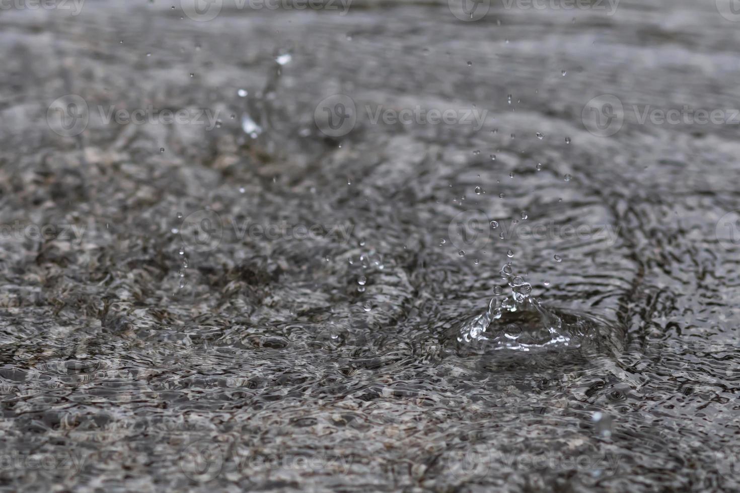 Rain drops in the water heavy on asphalt shade of black shadow and reflection of dark sky in the city. high contrast during autumn photo