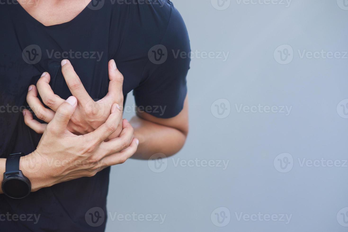 hombre con dolor de pecho - ataque al corazón al aire libre. o el ejercicio pesado hace que el cuerpo sufra enfermedades del corazón foto