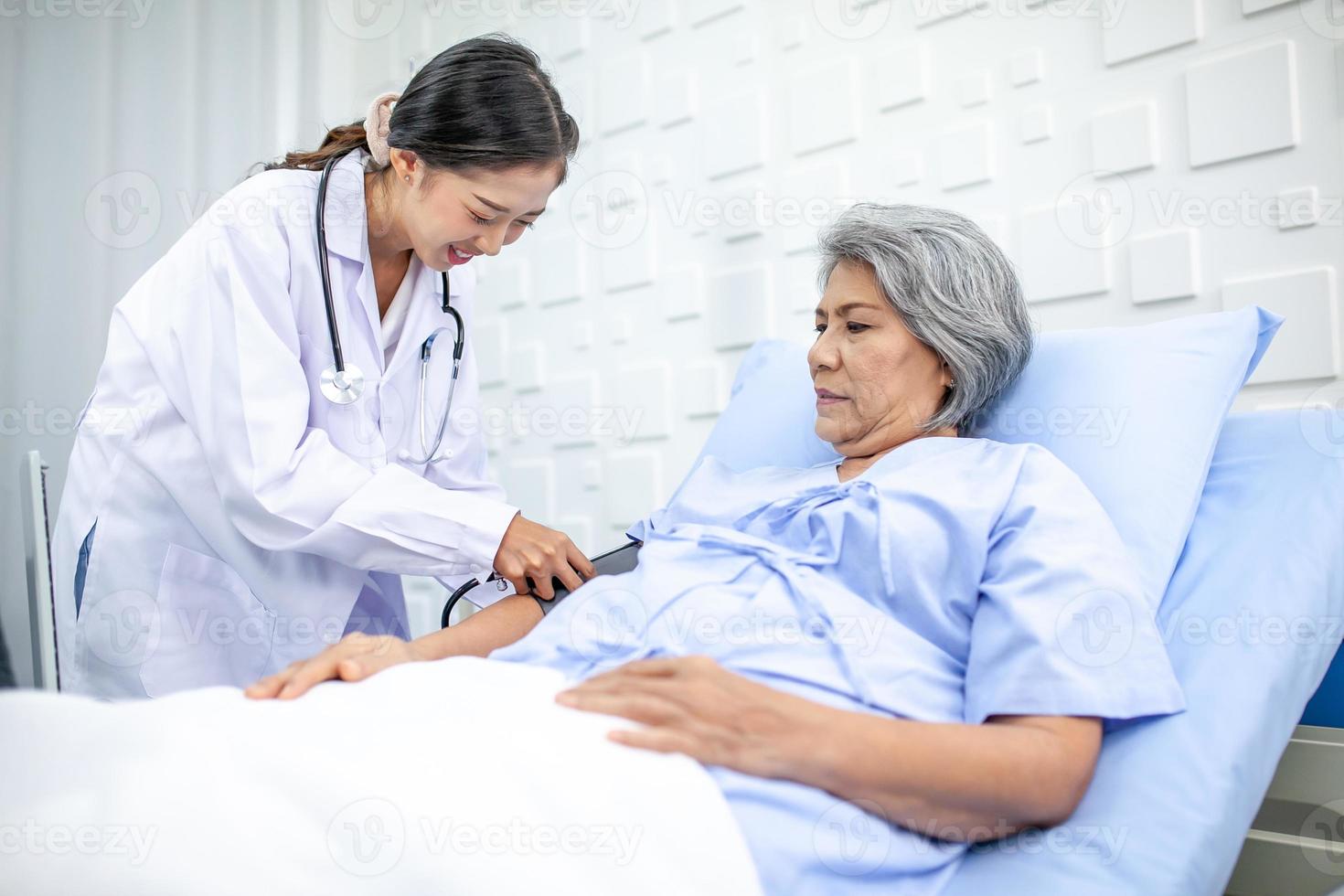 Beautiful asian doctor with stethoscope and document folder, examine the symptom for patient in the recovery room. Healthcare and medicine concept. photo
