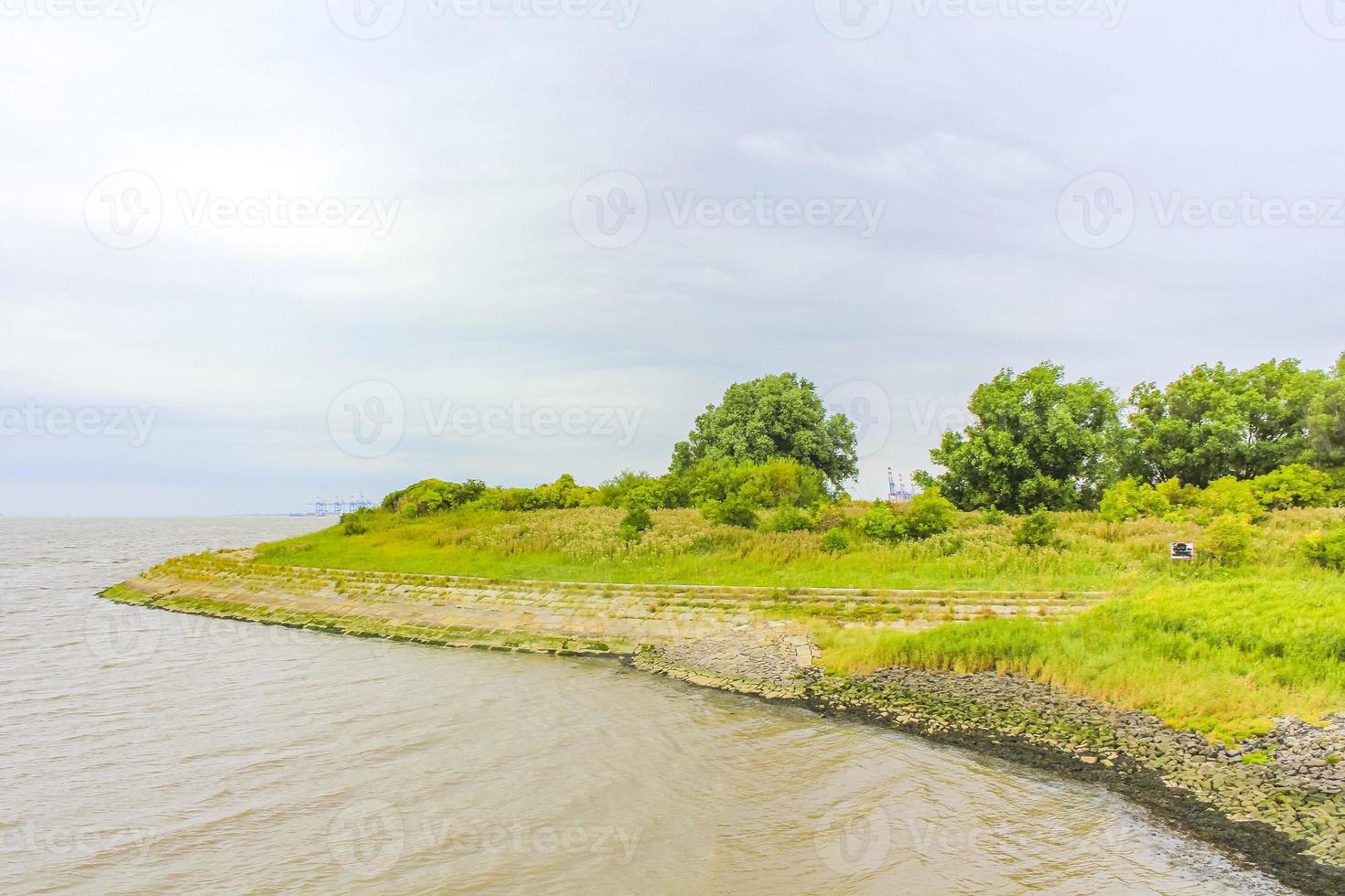 Dyke dike mudflat waves landscape North Sea coast Nordenham Germany. photo