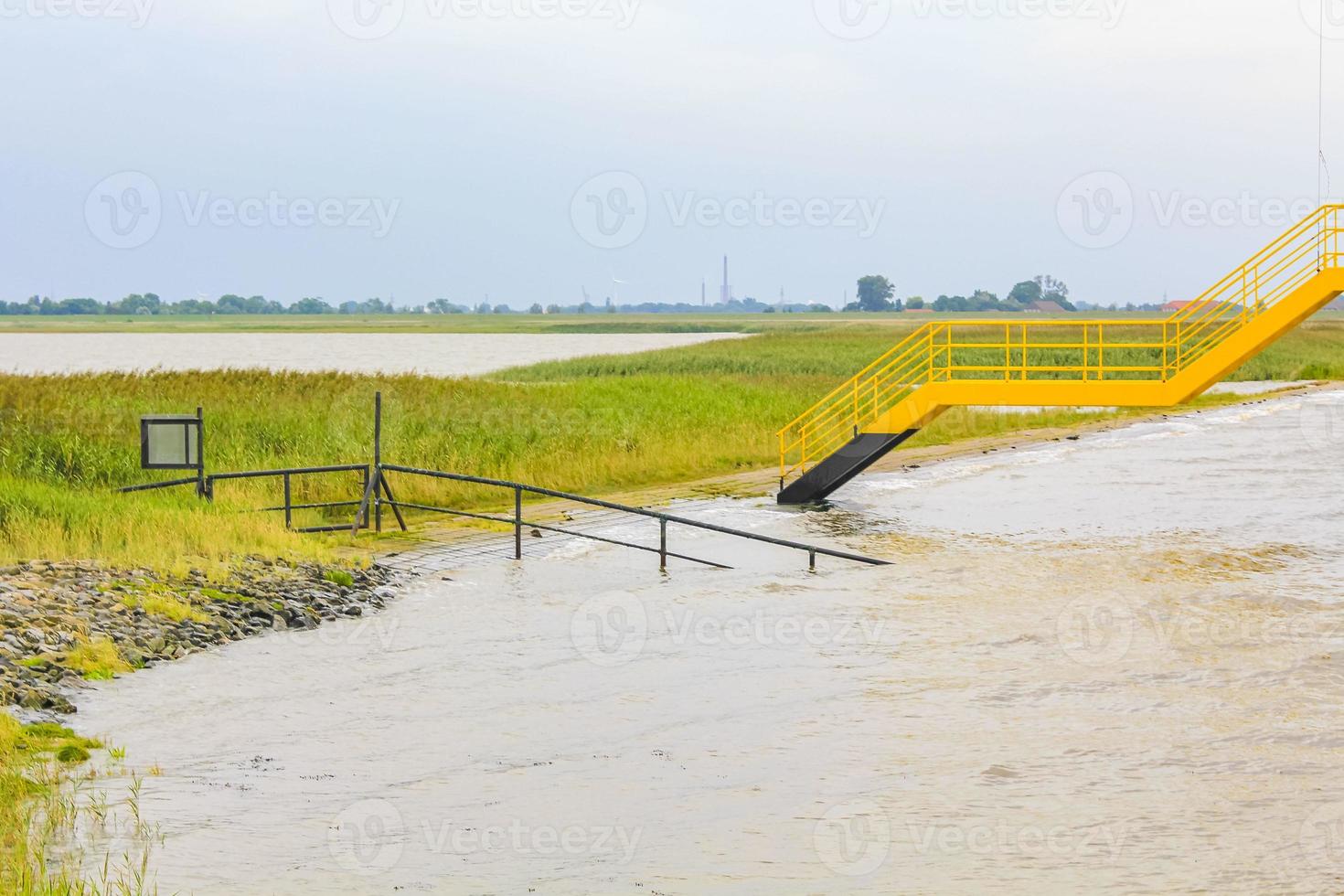 Dyke dike mudflat waves landscape North Sea coast Nordenham Germany. photo