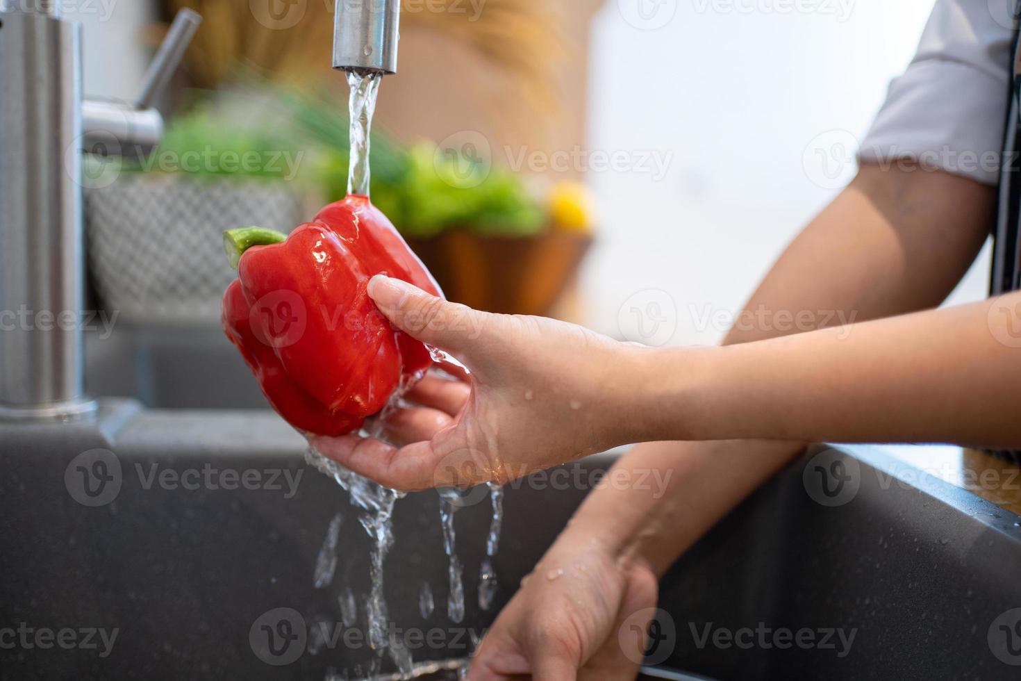 Washing vegetables. A woman in the kitchen. photo