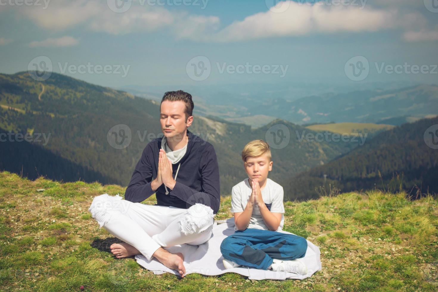 Zen-like father and son meditating on a meadow. photo