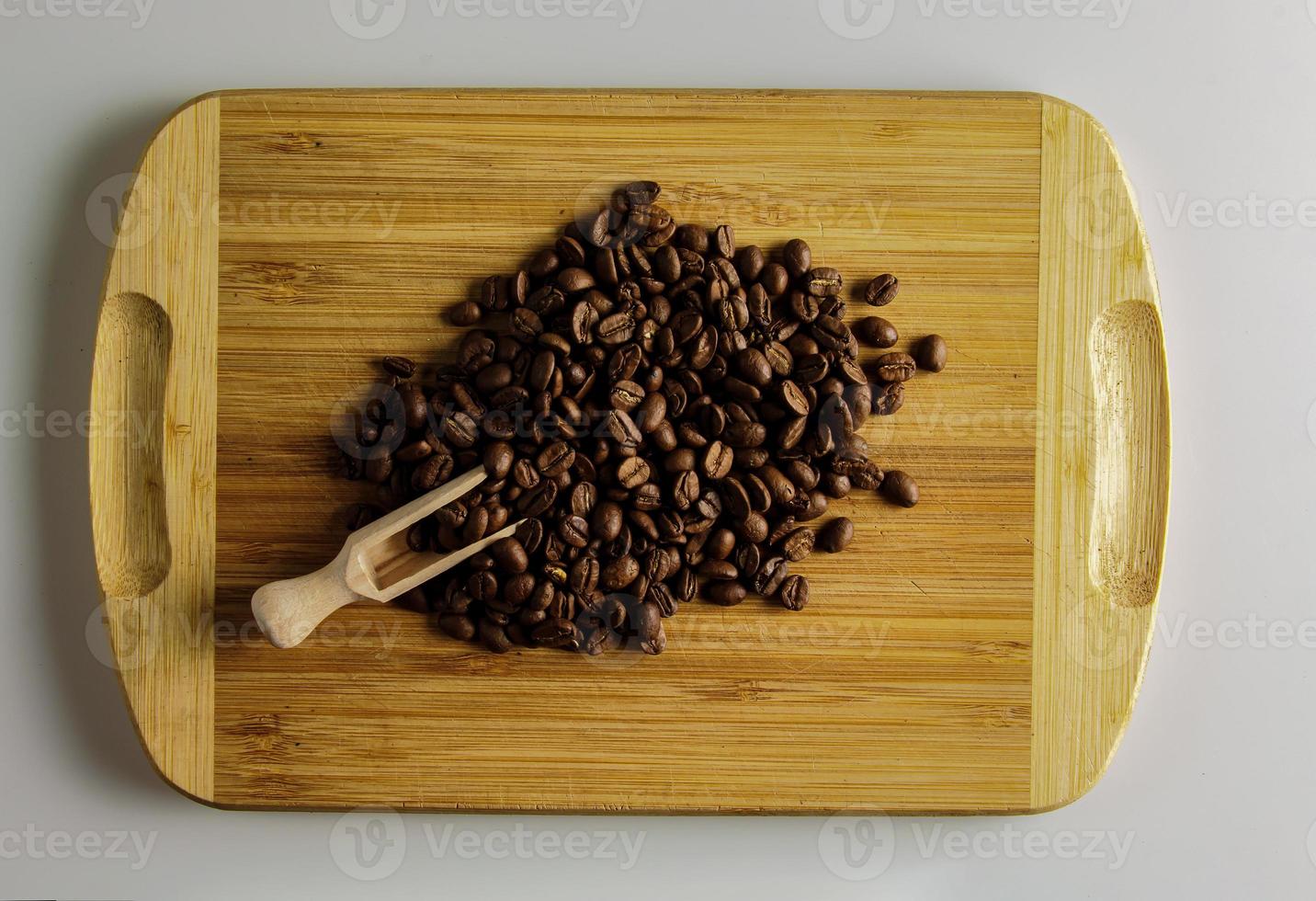 Roasted Cuban coffee of the highest quality. Wooden spatula with coffee beans and a handful of coffee beans on a wooden board photo