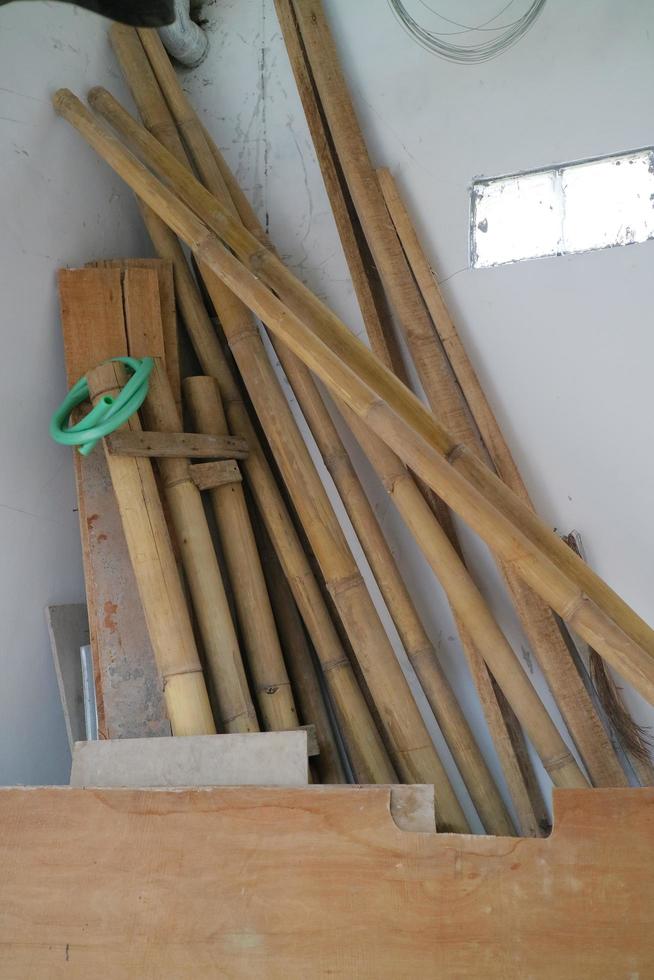 pile of used boards and bamboo in the corner of the room photo