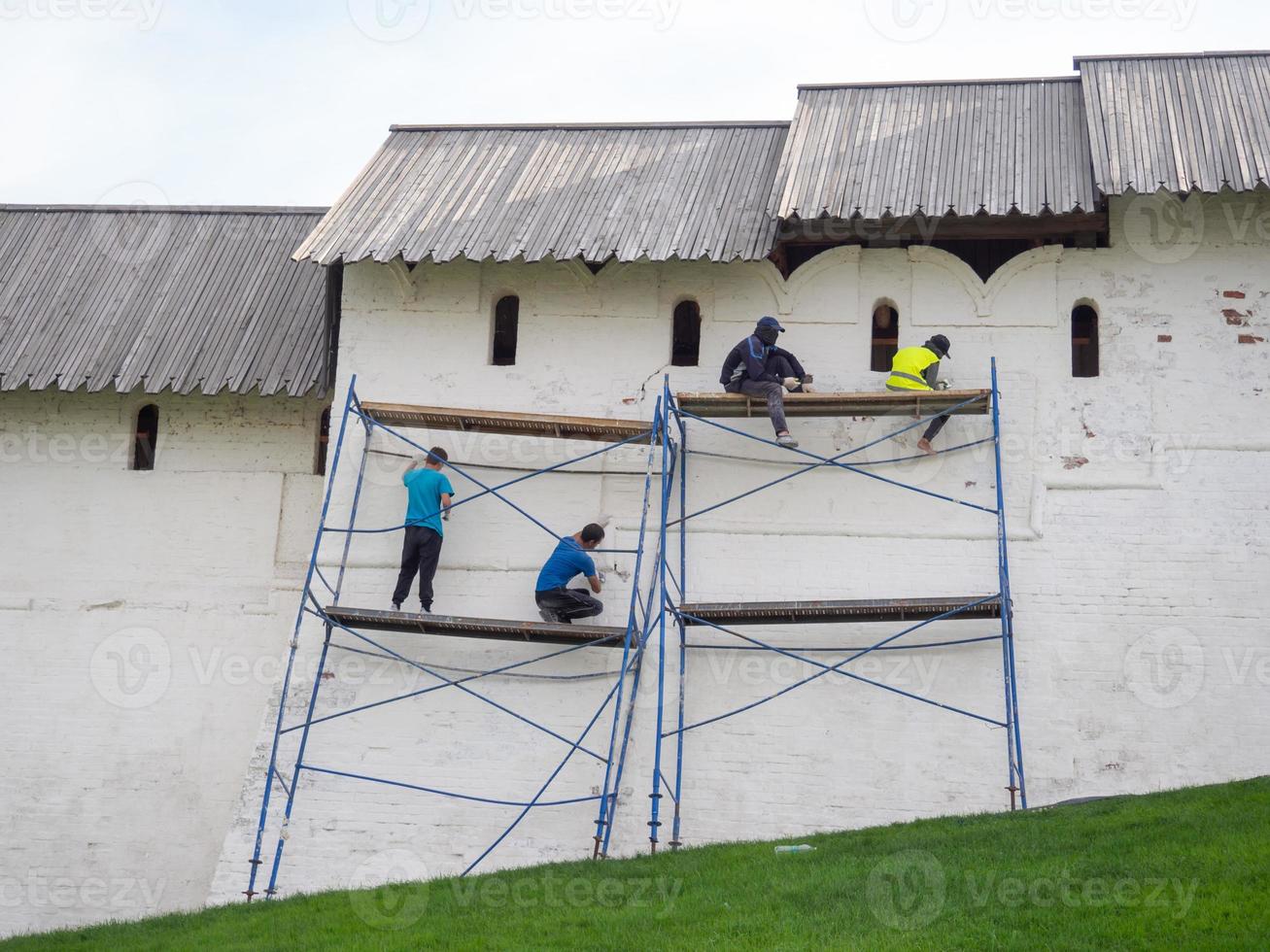 Workers on the scaffolding are repairing an ancient landmark. photo