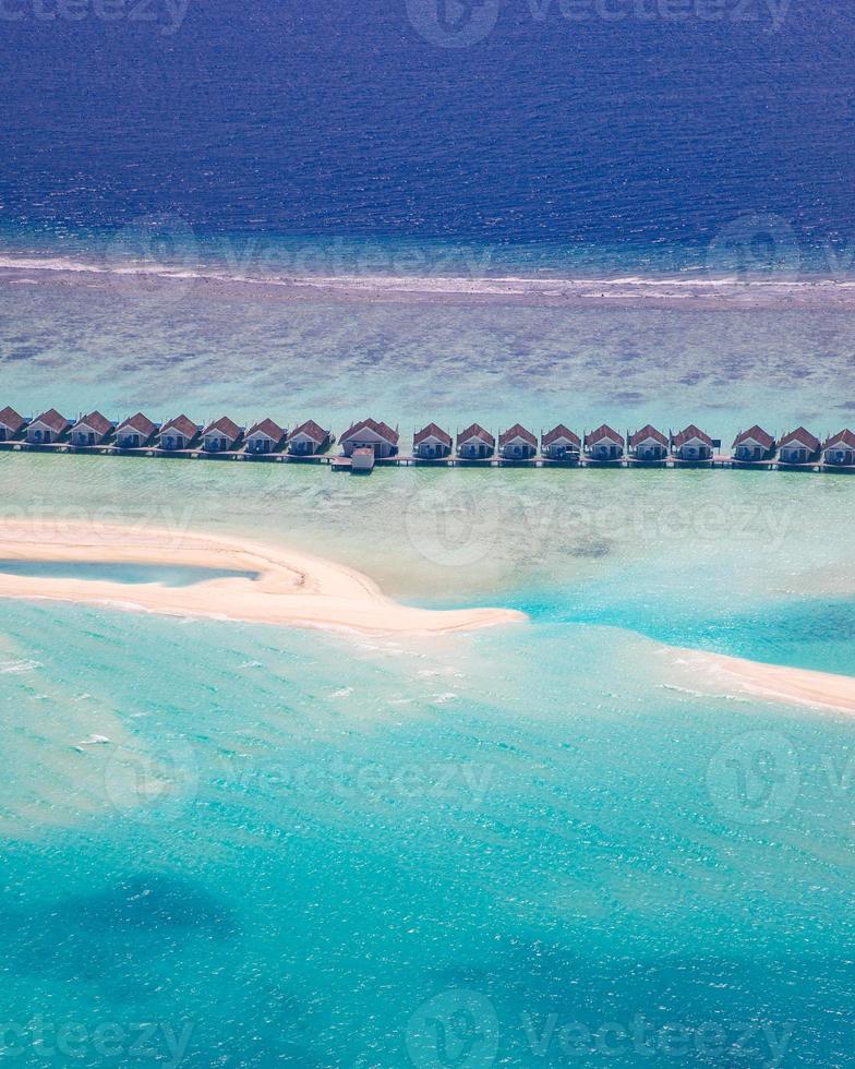 Amazing atoll and island in Maldives from aerial view. Tranquil tropical landscape and seascape with palm trees on white sandy beach, peaceful nature in luxury resort island. Summer holiday mood photo