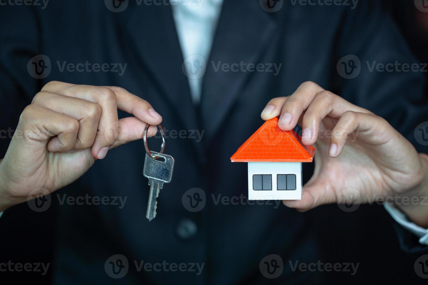 Real estate agent with house model and keys, real estate and property concept photo