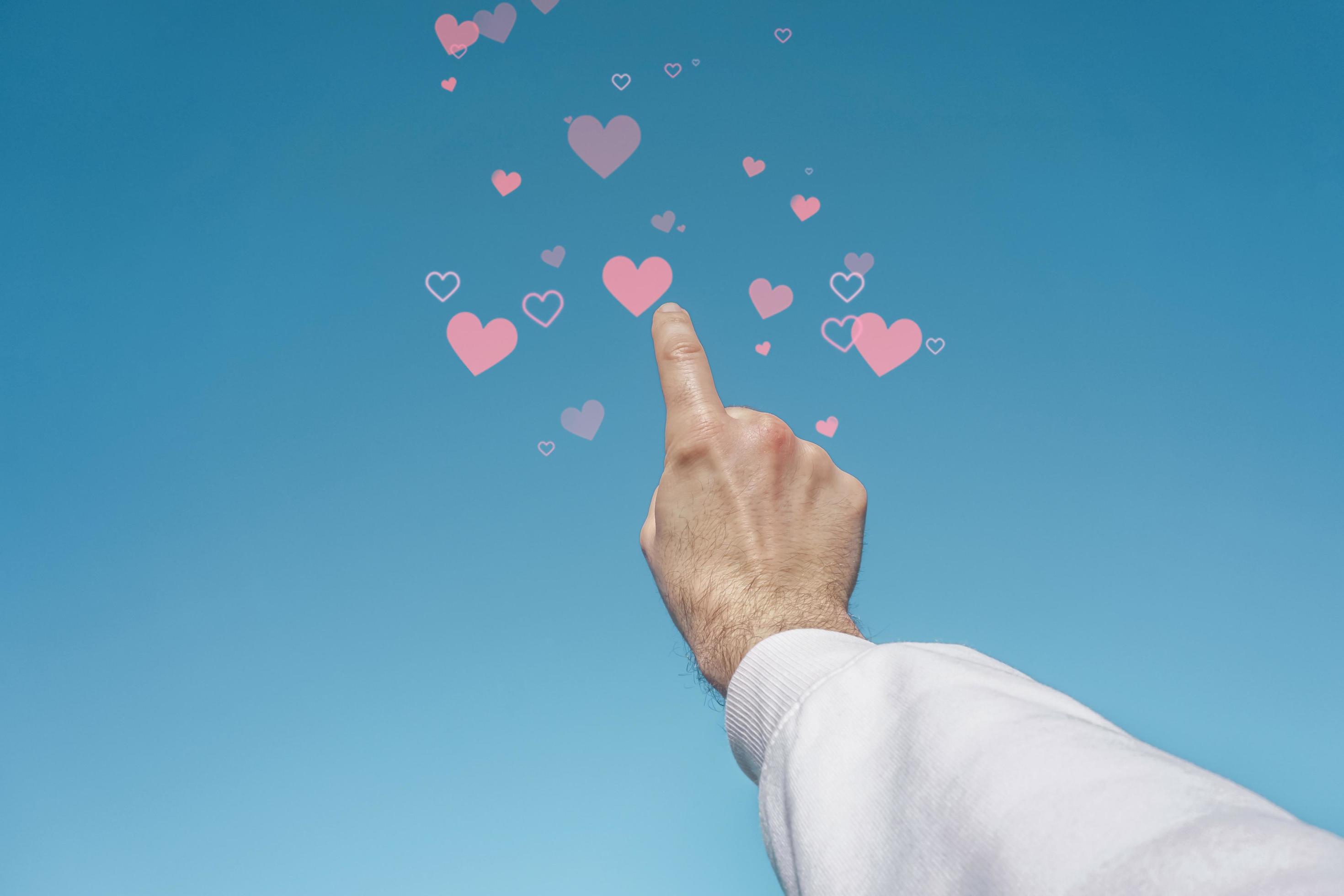 hand up in the sky touching a heart shape, love emotions in valentine's day  11903746 Stock Photo at Vecteezy