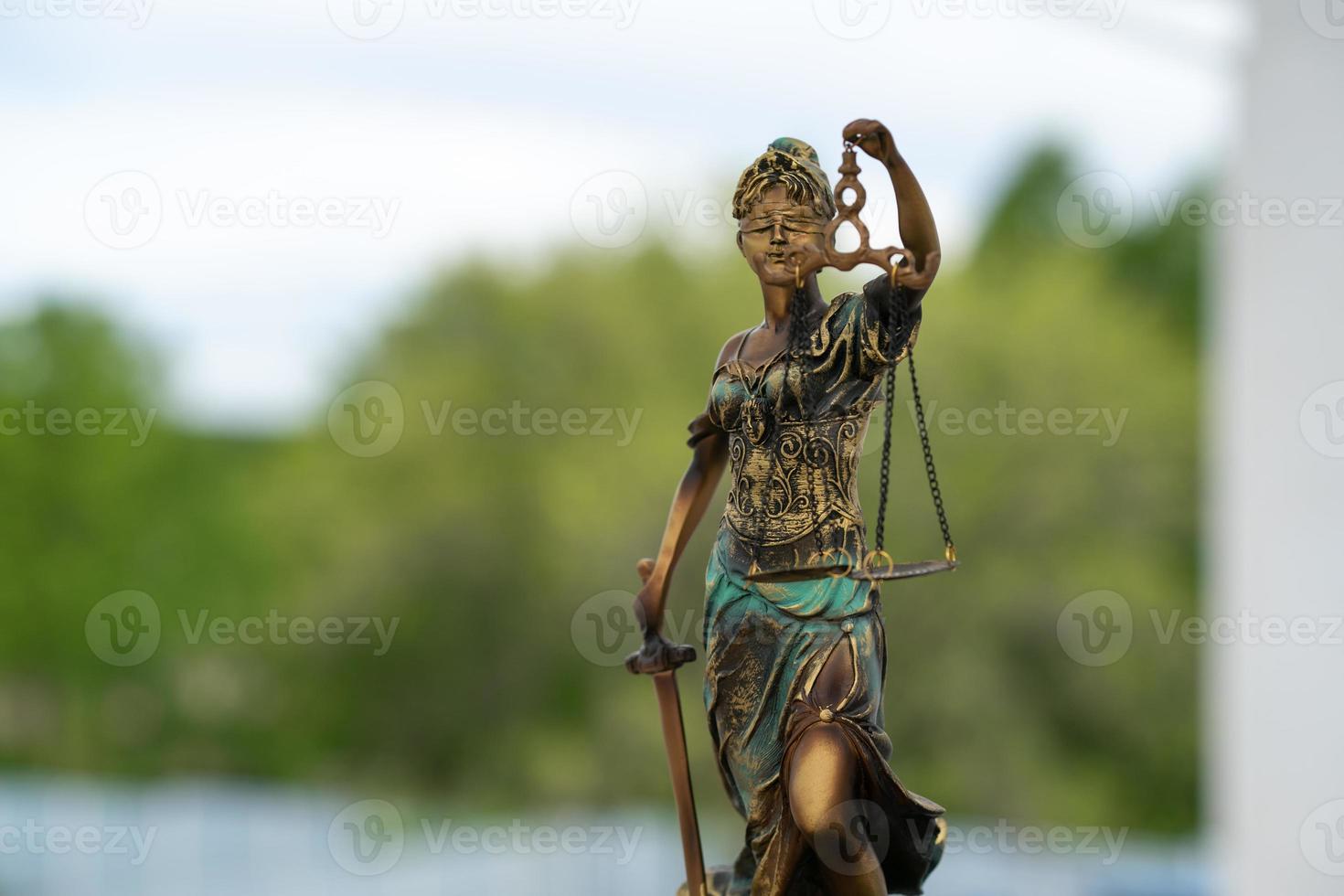 estatua de themis contra un fondo de naturaleza. símbolo de justicia y ley, crimen y castigo. foto