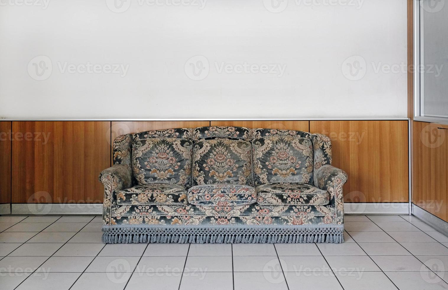 Old sofa in a somewhat bland environment in a waiting room photo