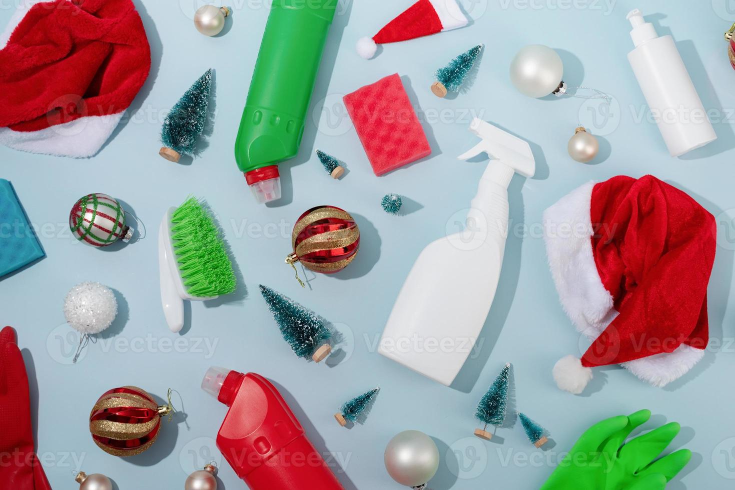 Cleaning tools and Christmas decorations top view flat lay on blue background, pattern photo