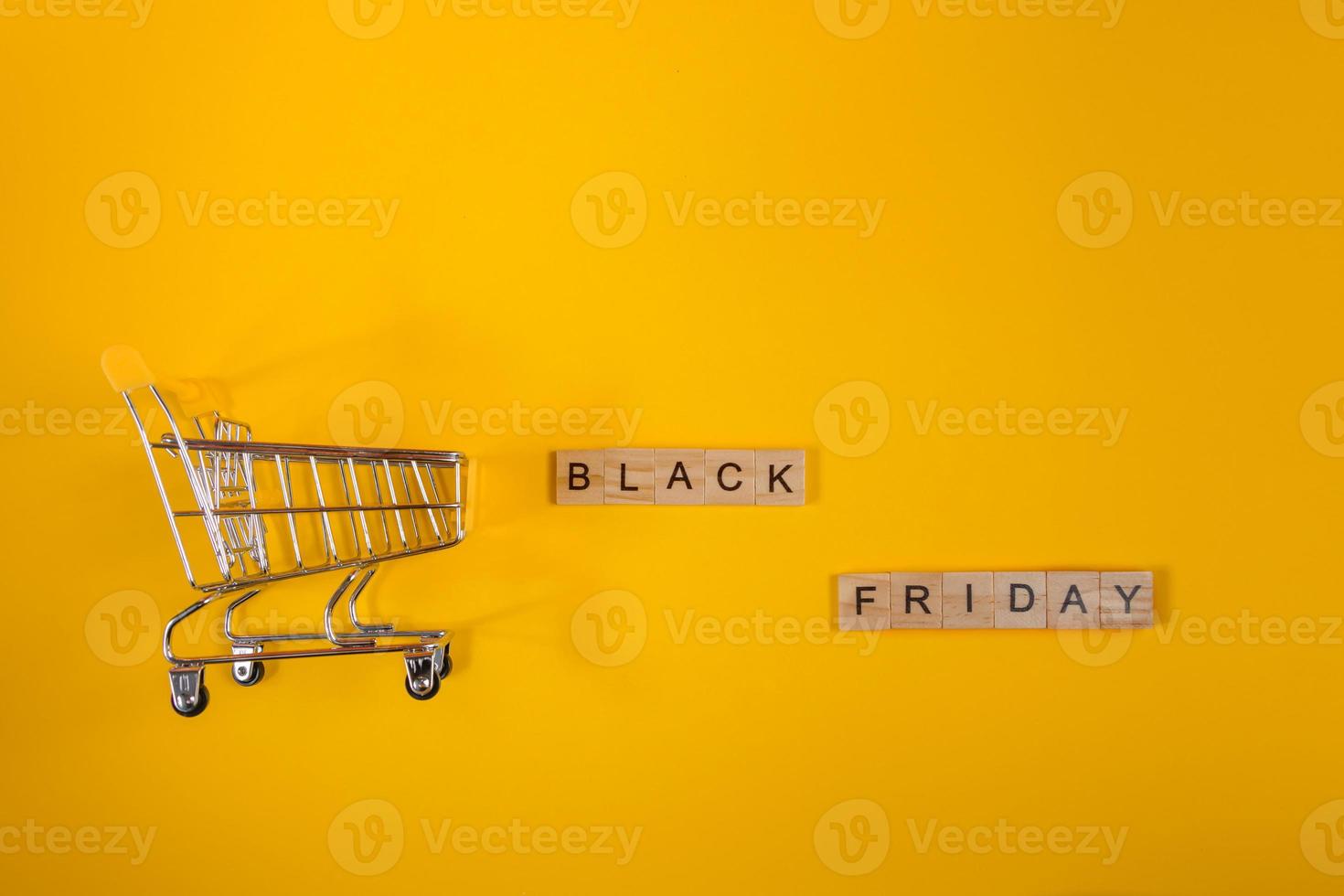 Sale and Black Friday concept. Mini shopping cart on yellow background. photo
