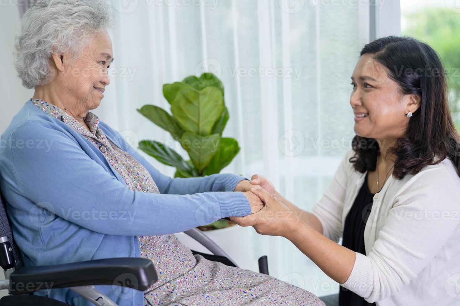 Caregiver help Asian senior or elderly old lady woman sitting on wheelchair at home. photo