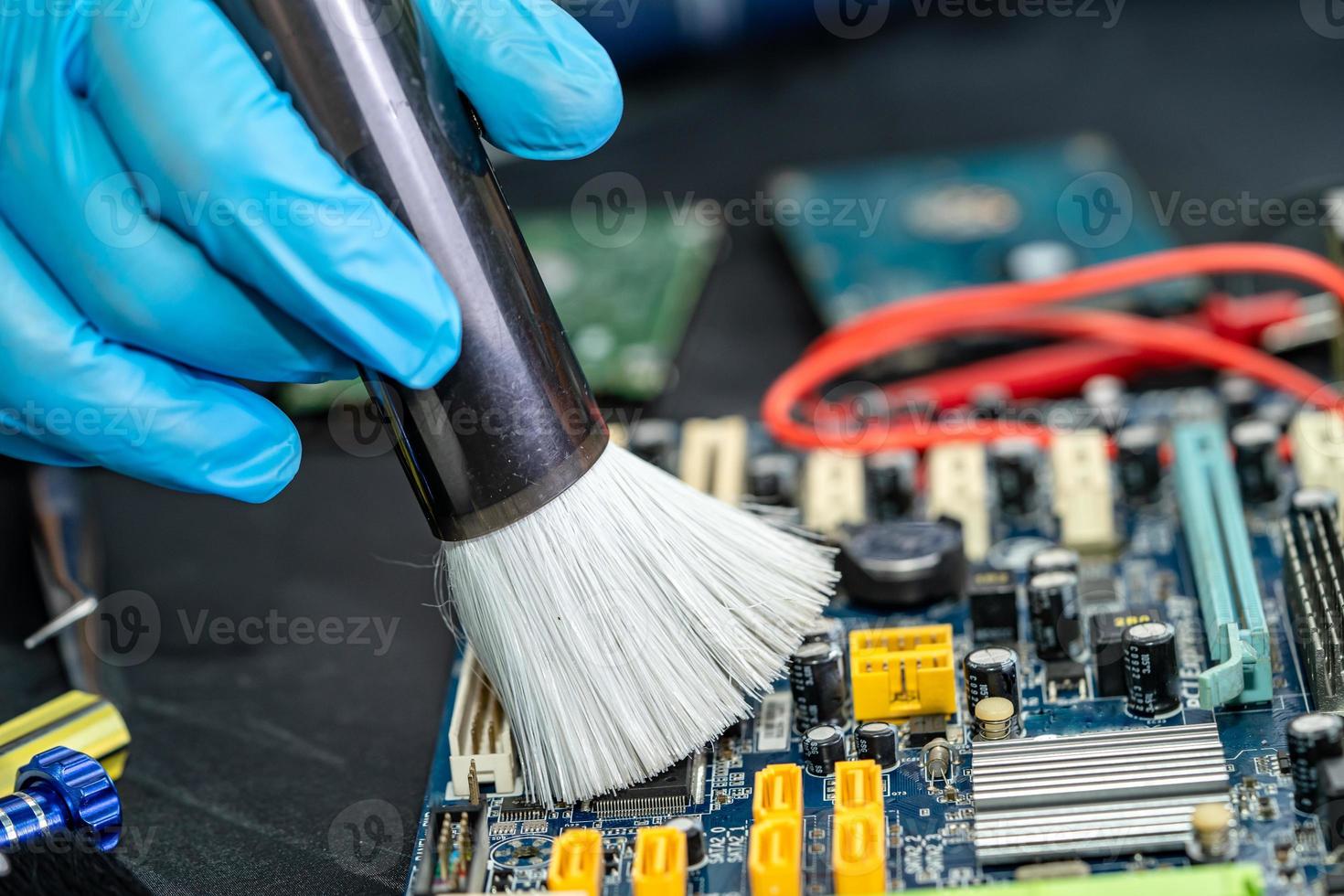 Technician use brush and air blower ball to clean dust in circuit board computer. Repair upgrade and maintenance technology. photo