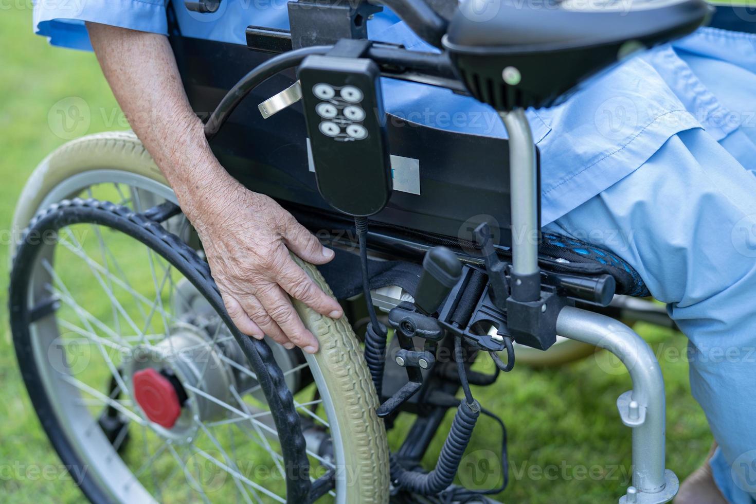 Asian senior or elderly old lady woman patient on electric wheelchair with remote control at nursing hospital ward, healthy strong medical concept photo