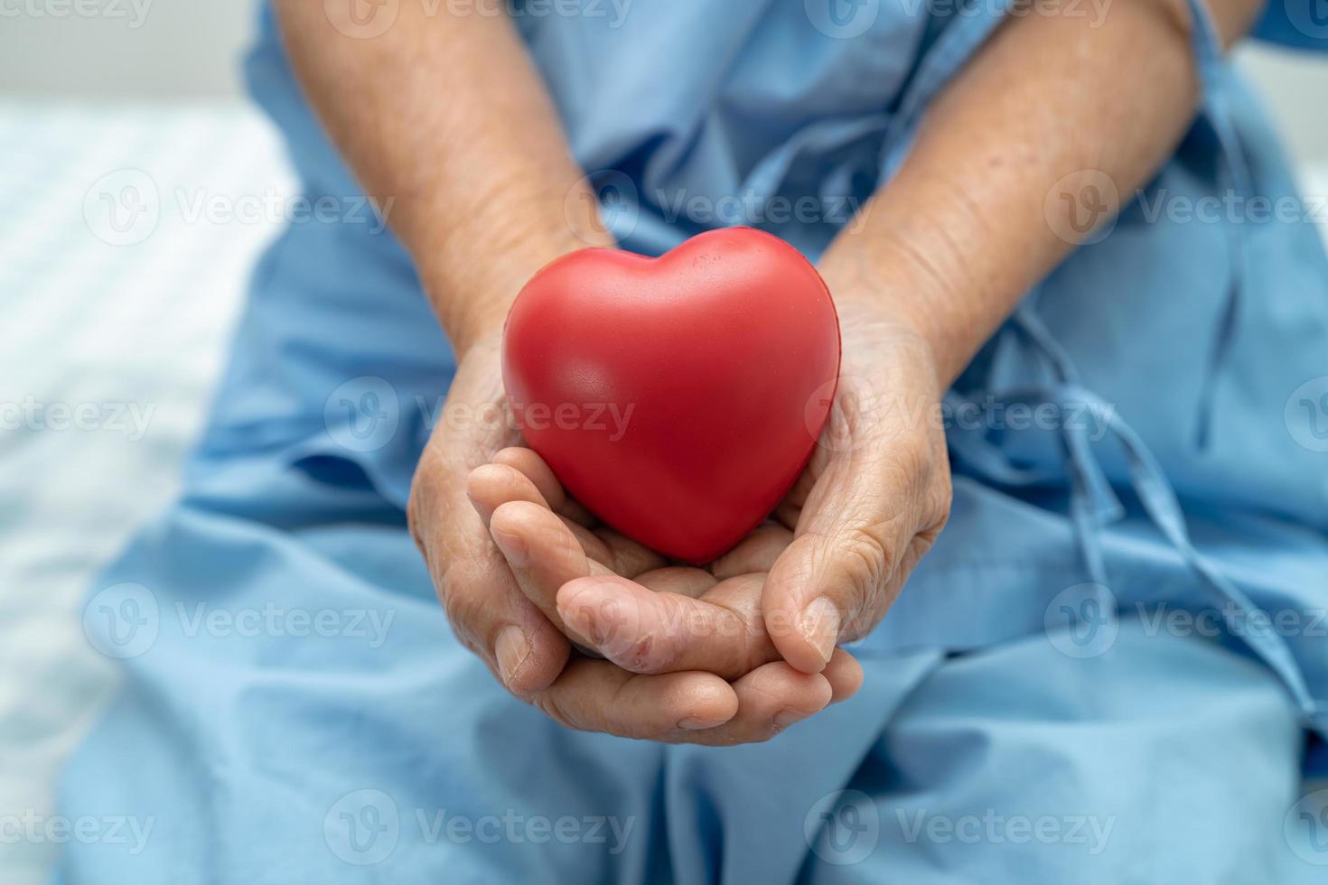 Asian senior or elderly old lady woman patient holding red heart, healthy strong medical concept. photo