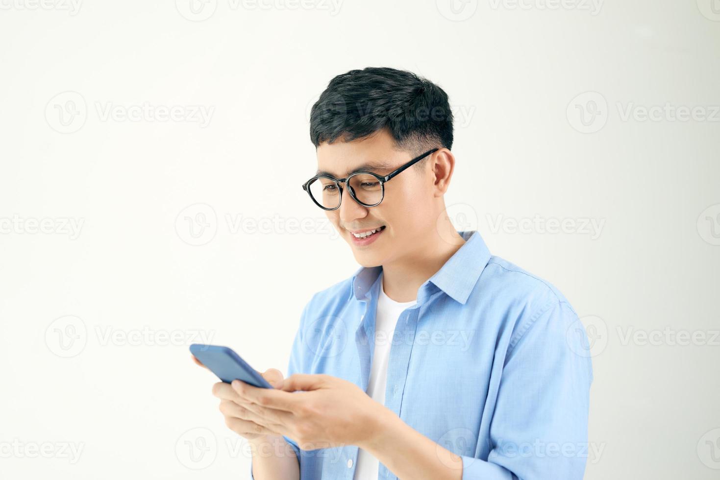 Atractivo joven con smartphone sobre fondo blanco. foto