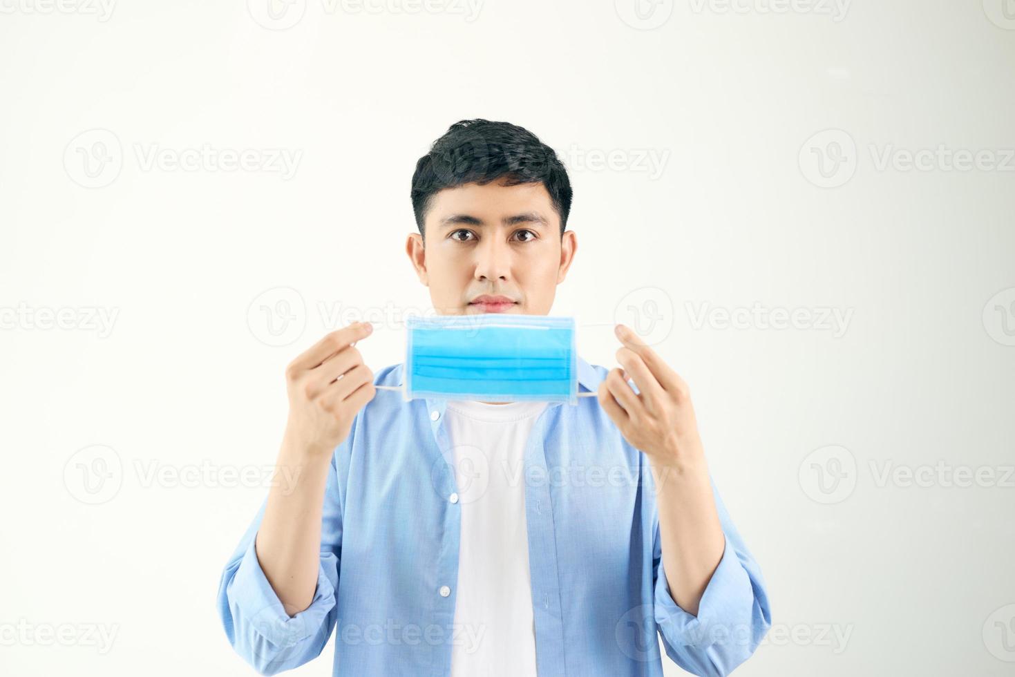 COVID-19 Coronavirus portrait handsome young asian man wearing mask protection from covid 19 isolated on white background in studio. Asian man people. COVID-19 concept. photo