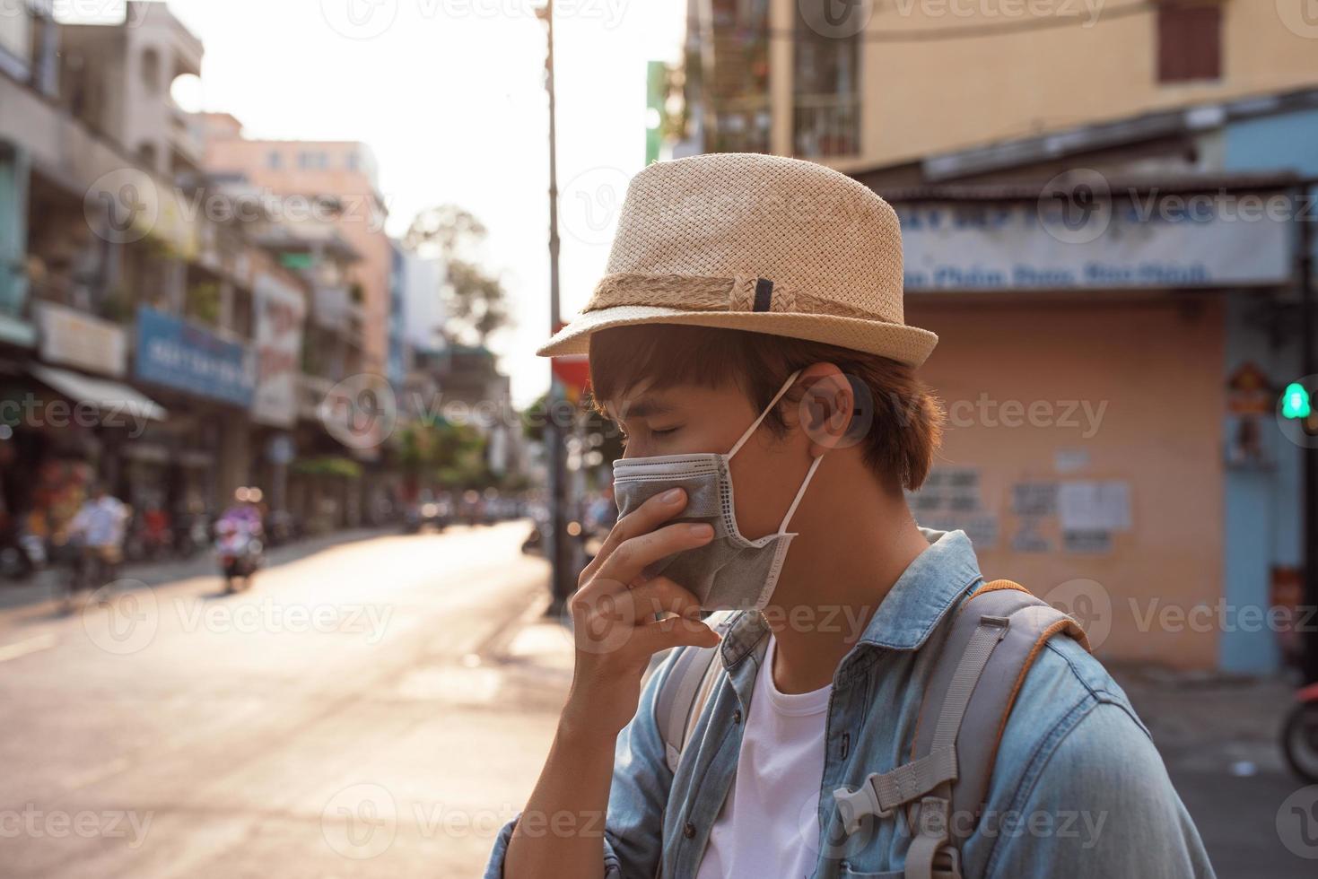 Tourist man with mask having a coffee while walking on street, travel concept in the new normal photo