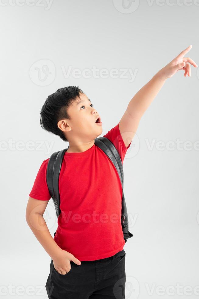 Beautiful student kid boy wearing backpack holding book over isolated white background very happy pointing with hand and finger to the side photo