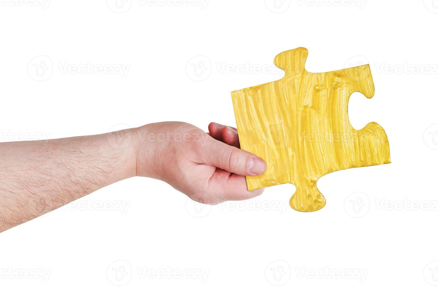 male hand with painted yellow puzzle piece photo