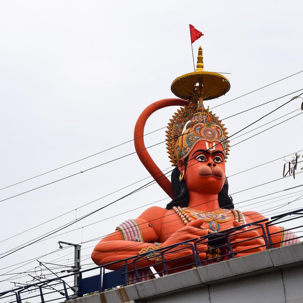 New Delhi, India - June 21, 2022 - Big statue of Lord Hanuman near the delhi metro bridge situated near Karol Bagh, Delhi, India, Lord Hanuman statue touching sky photo