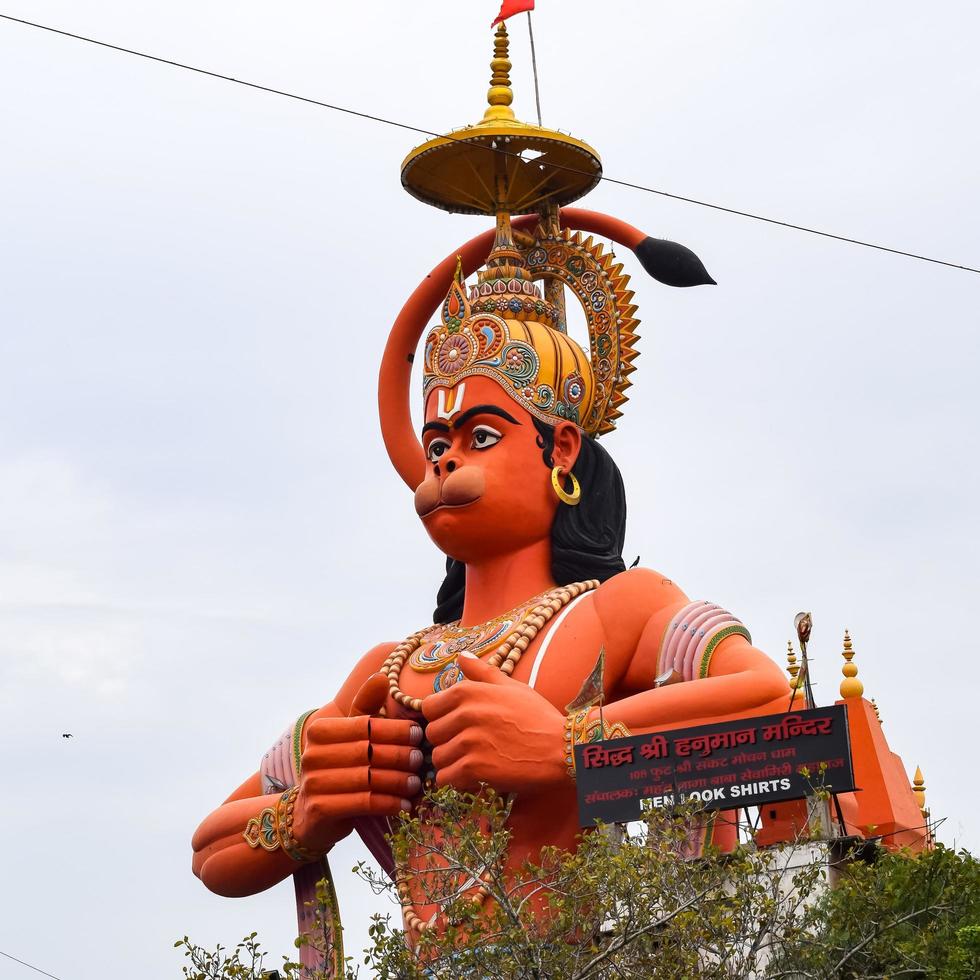 New Delhi, India - June 21, 2022 - Big statue of Lord Hanuman near the delhi metro bridge situated near Karol Bagh, Delhi, India, Lord Hanuman statue touching sky photo