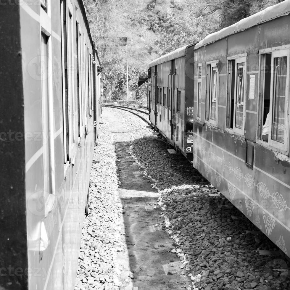 Toy Train moving on mountain slope, beautiful view, one side mountain, one side valley moving on railway to the hill, among green natural forest.Toy train from Kalka to Shimla in India-Black and White photo
