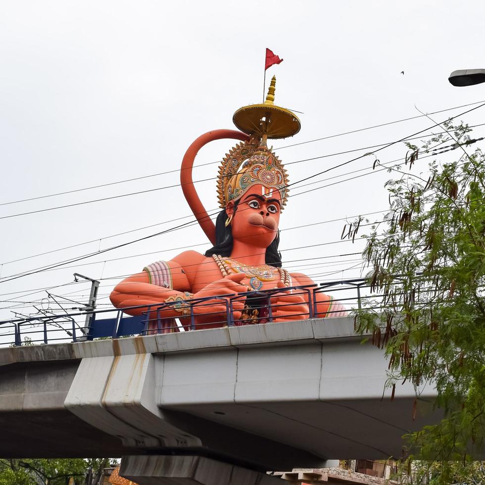 New Delhi, India - June 21, 2022 - Big statue of Lord Hanuman near the delhi metro bridge situated near Karol Bagh, Delhi, India, Lord Hanuman statue touching sky photo