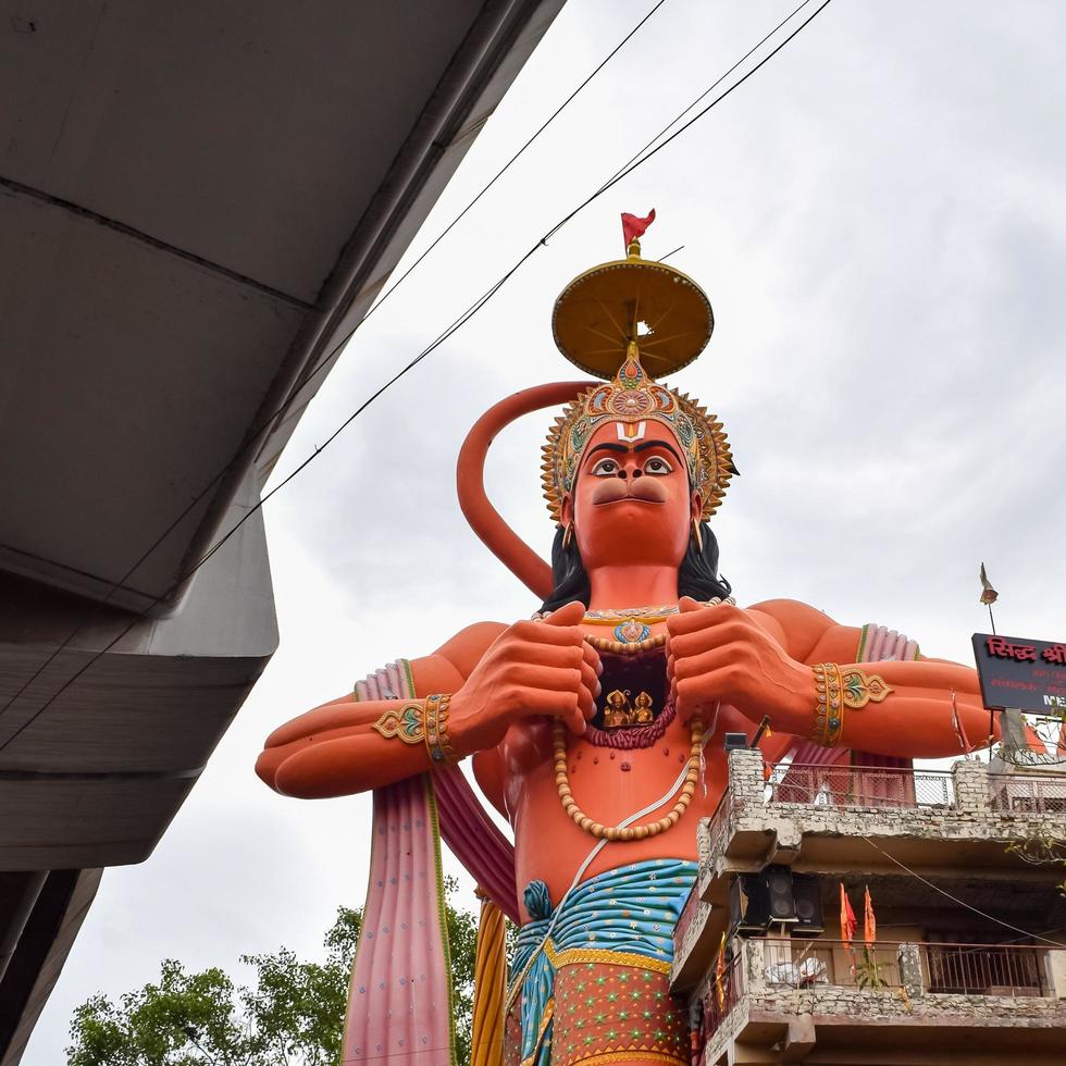 New Delhi, India - June 21, 2022 - Big statue of Lord Hanuman near the delhi metro bridge situated near Karol Bagh, Delhi, India, Lord Hanuman statue touching sky photo