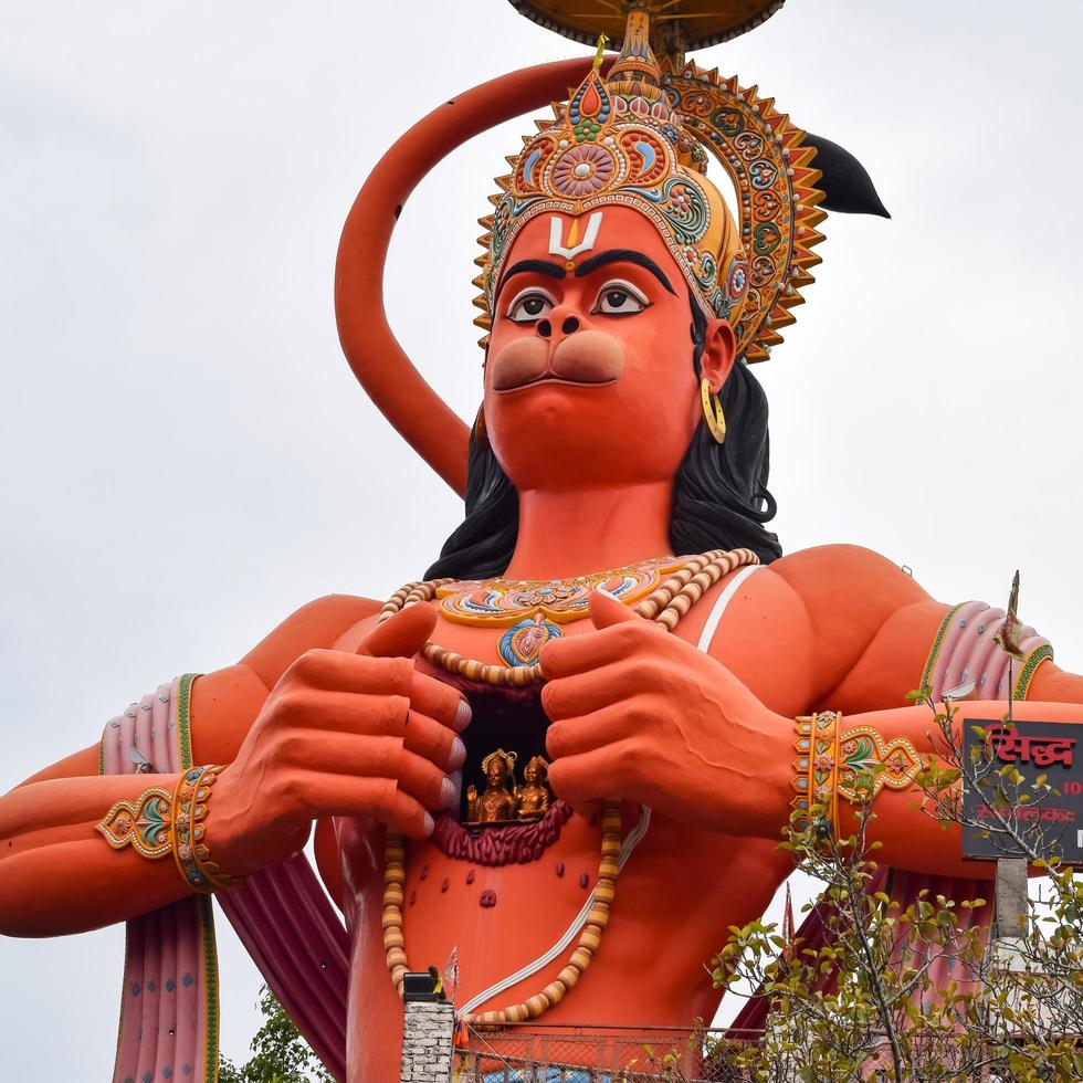 New Delhi, India - June 21, 2022 - Big statue of Lord Hanuman near the delhi metro bridge situated near Karol Bagh, Delhi, India, Lord Hanuman statue touching sky photo