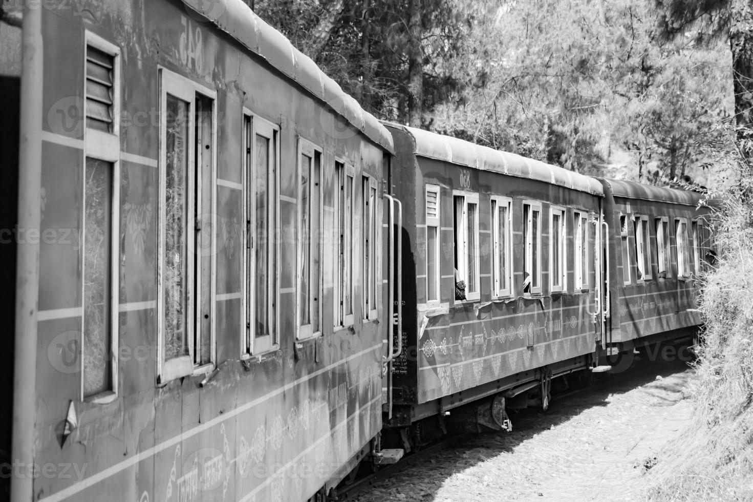 Toy Train moving on mountain slope, beautiful view, one side mountain, one side valley moving on railway to the hill, among green natural forest.Toy train from Kalka to Shimla in India-Black and White photo