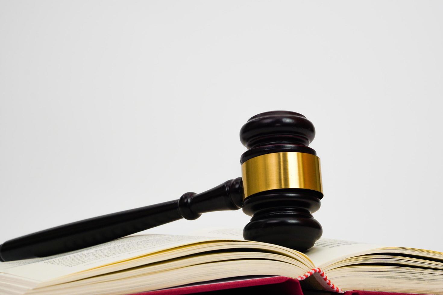 Close up of judge gavel, lawyer, law, justice placed on law book on white background. photo