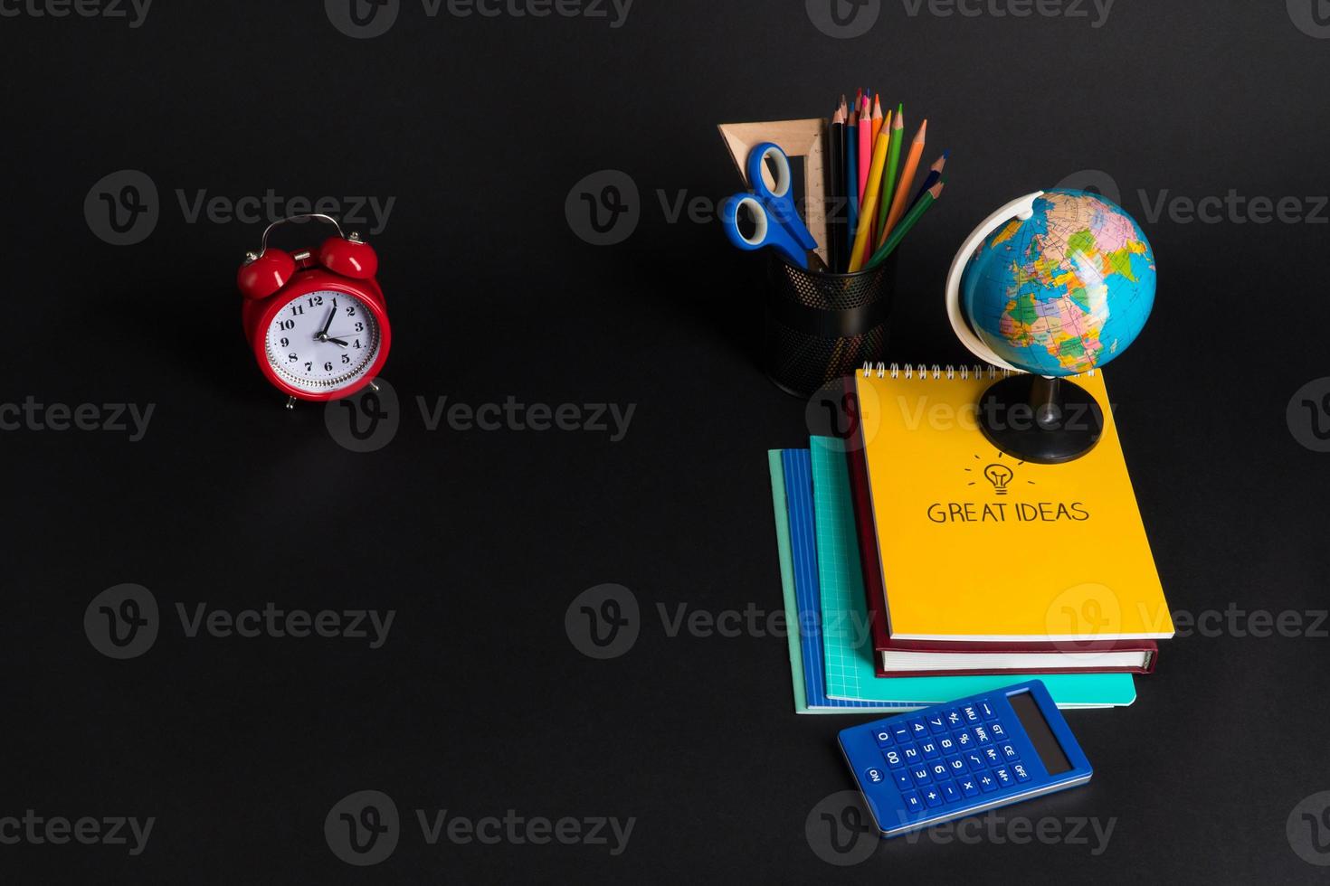 Some educational school supplies on a black background. photo