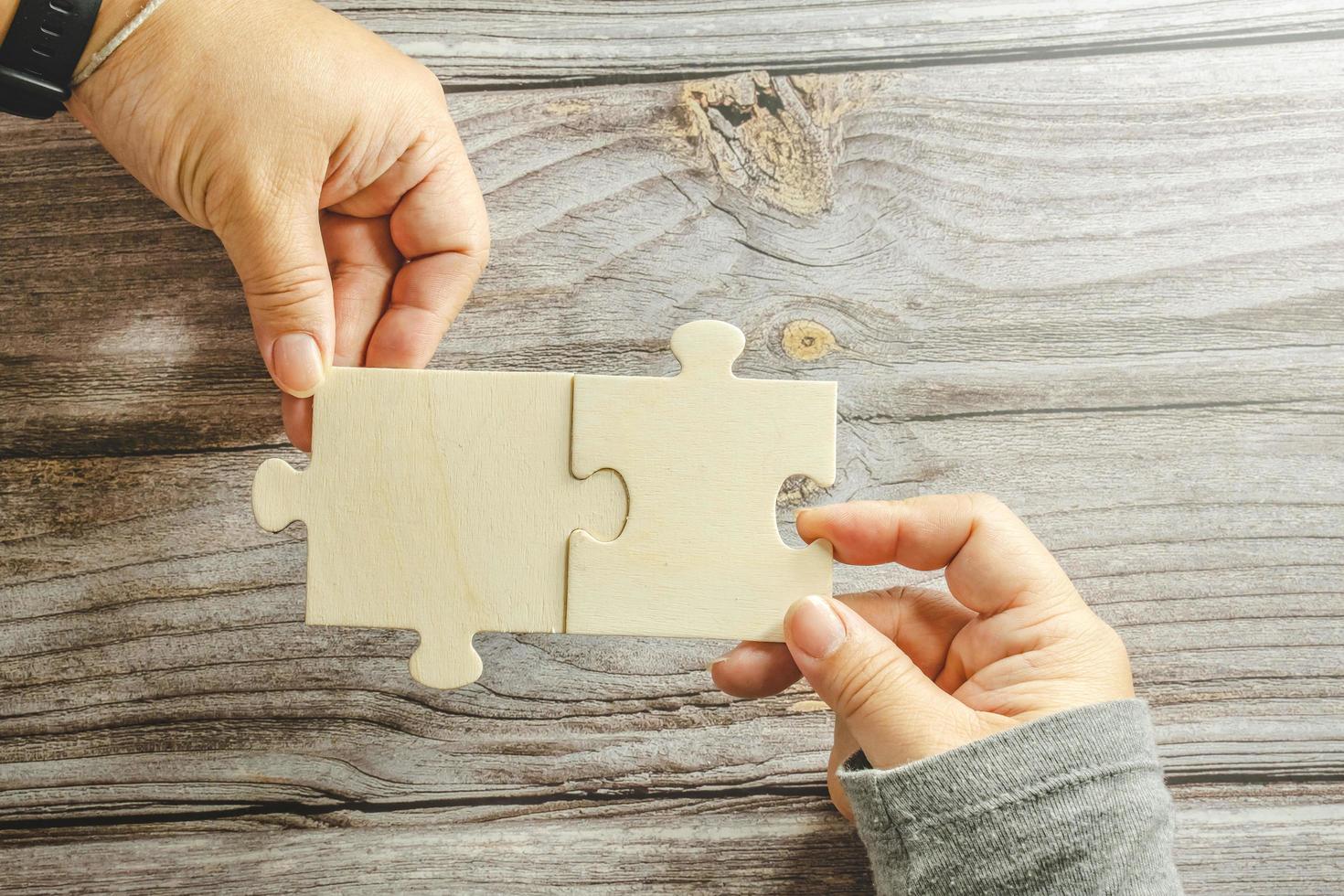 White jigsaw puzzle connecting together. Team business success partnership or teamwork concept. A group of business people assembling jigsaw puzzle. Business solutions, success and strategy concept. photo