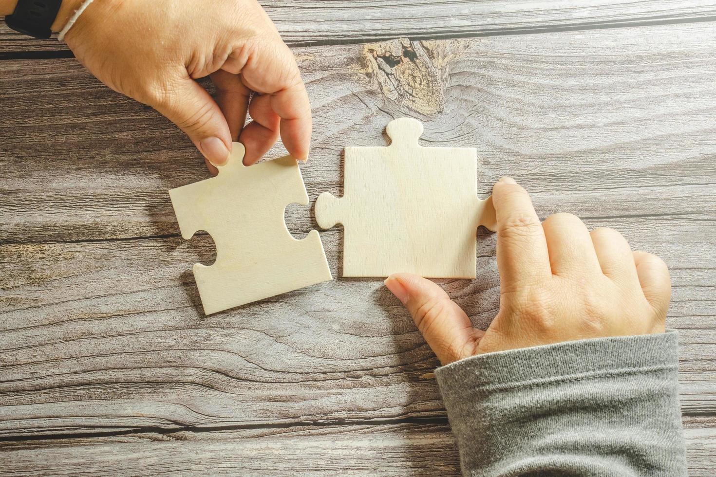 White jigsaw puzzle connecting together. Team business success partnership or teamwork concept. A group of business people assembling jigsaw puzzle. Business solutions, success and strategy concept. photo