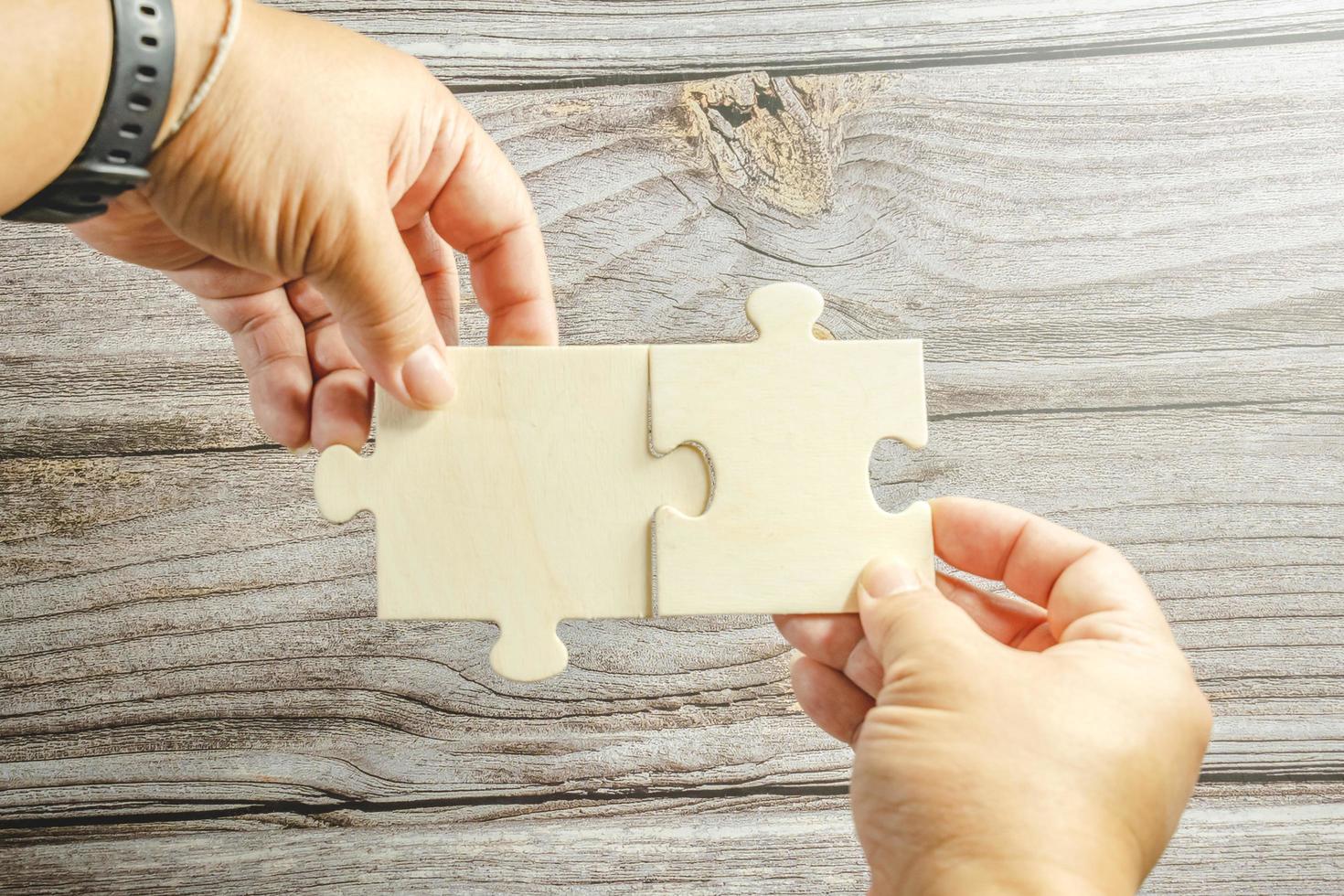 White jigsaw puzzle connecting together. Team business success partnership or teamwork concept. A group of business people assembling jigsaw puzzle. Business solutions, success and strategy concept. photo