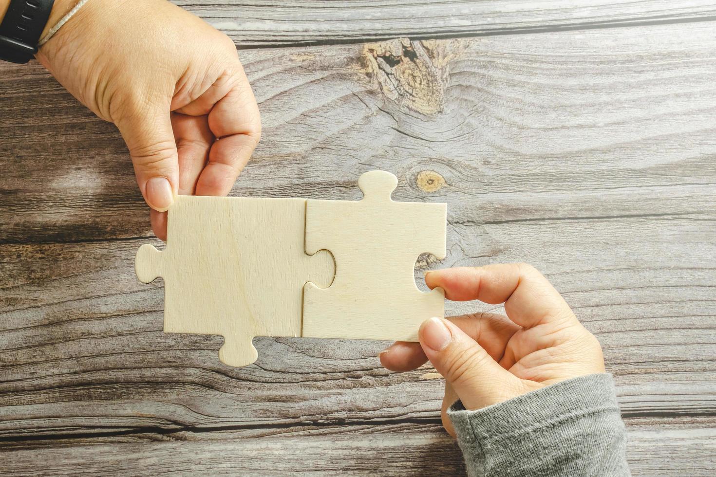 White jigsaw puzzle connecting together. Team business success partnership or teamwork concept. A group of business people assembling jigsaw puzzle. Business solutions, success and strategy concept. photo