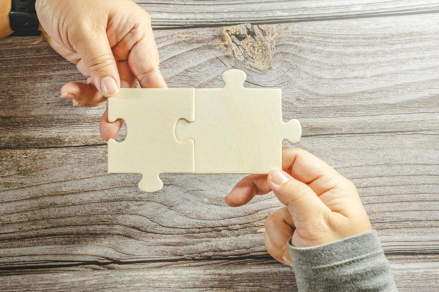 White jigsaw puzzle connecting together. Team business success partnership or teamwork concept. A group of business people assembling jigsaw puzzle. Business solutions, success and strategy concept. photo