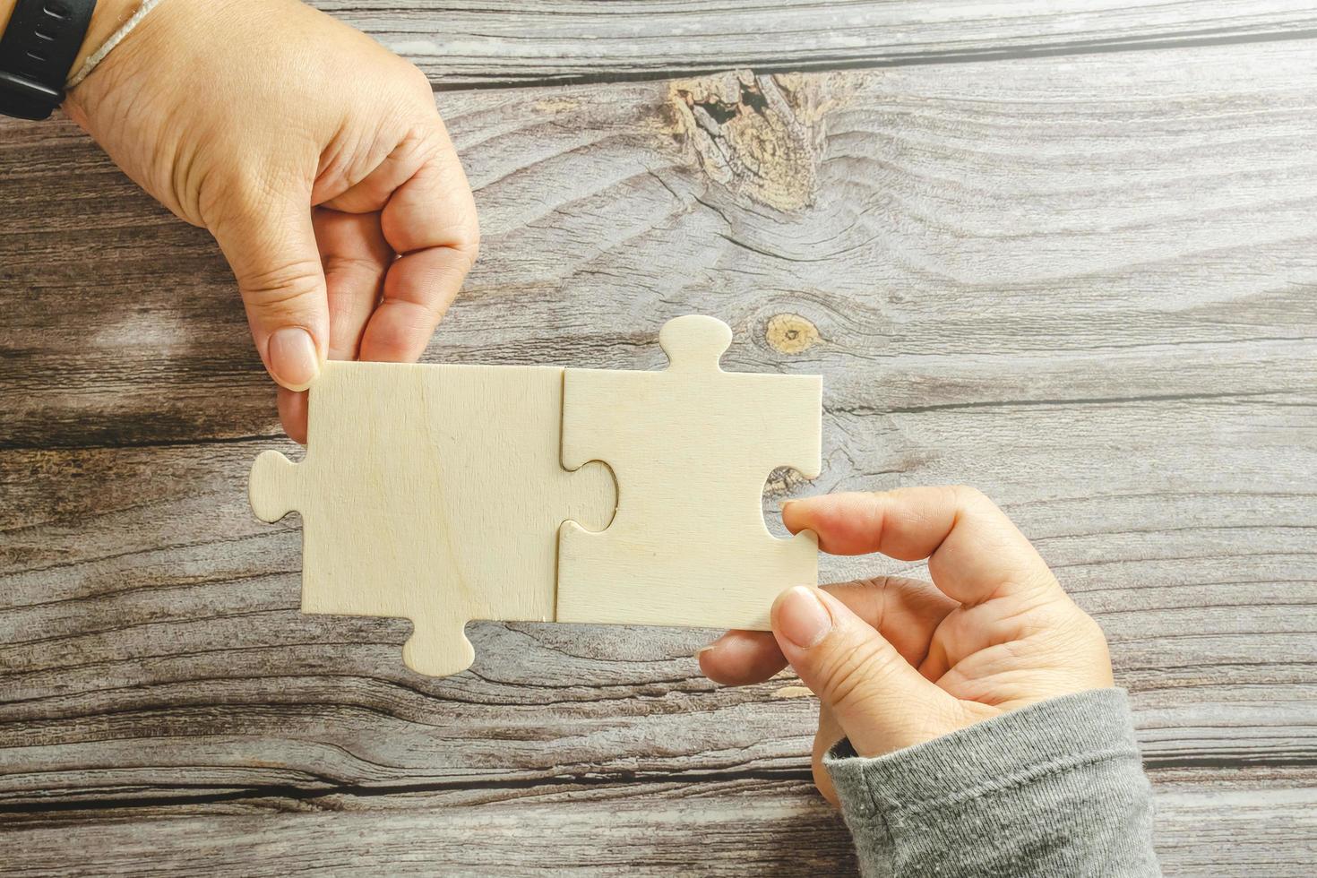 White jigsaw puzzle connecting together. Team business success partnership or teamwork concept. A group of business people assembling jigsaw puzzle. Business solutions, success and strategy concept. photo
