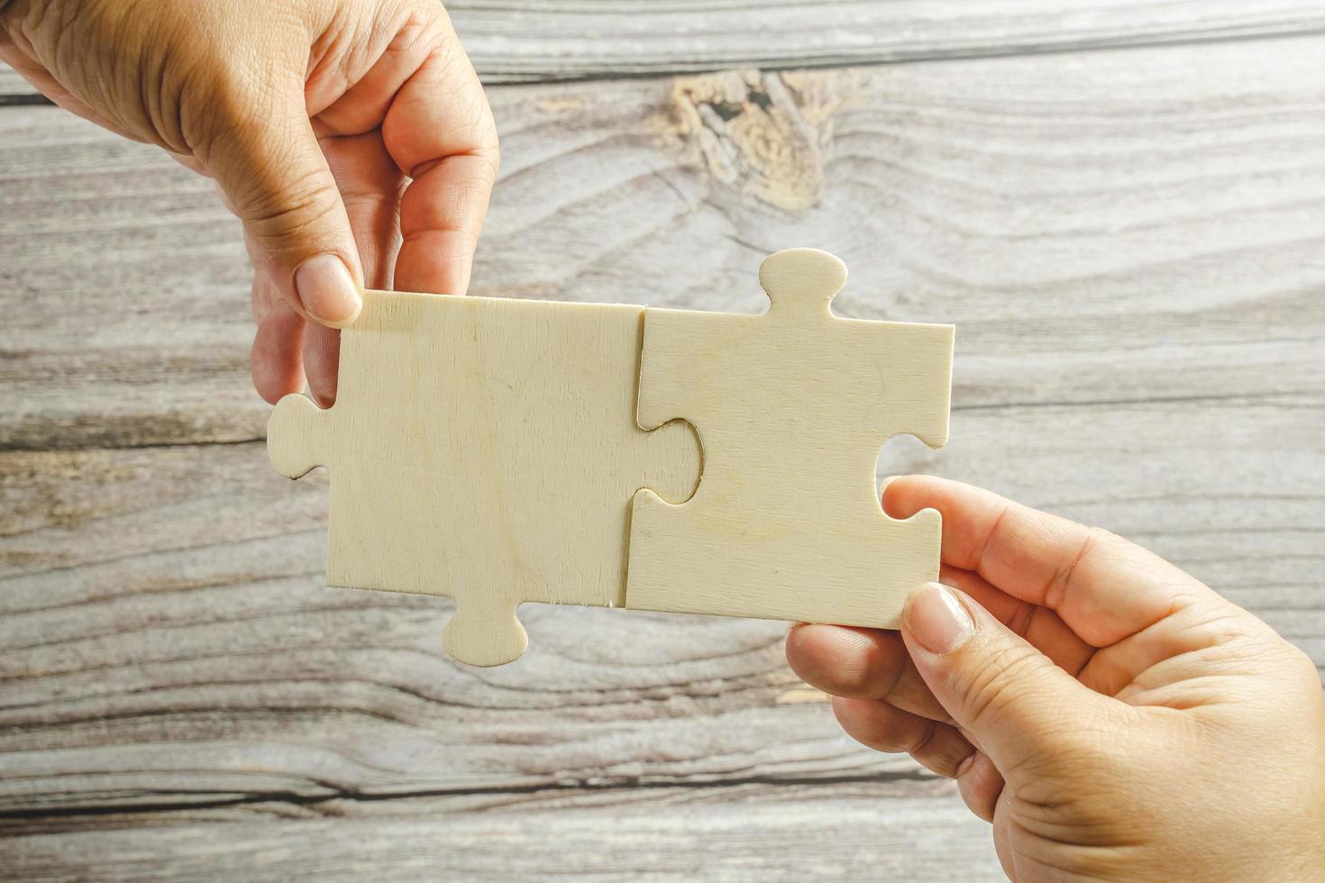 White jigsaw puzzle connecting together. Team business success partnership or teamwork concept. A group of business people assembling jigsaw puzzle. Business solutions, success and strategy concept. photo
